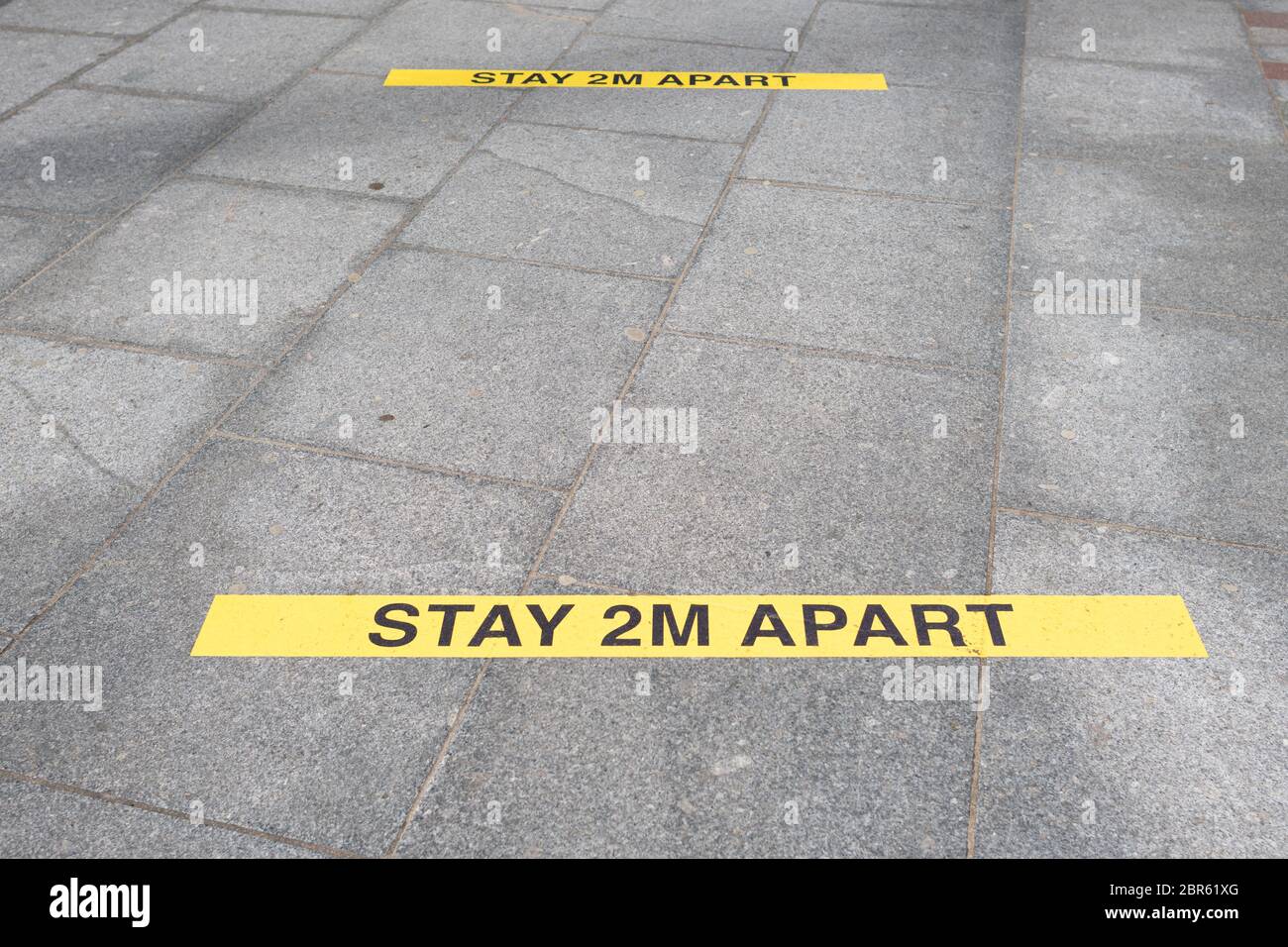 Bleiben Sie 2 m auseinander Schilder auf dem Boden - UK Stockfoto