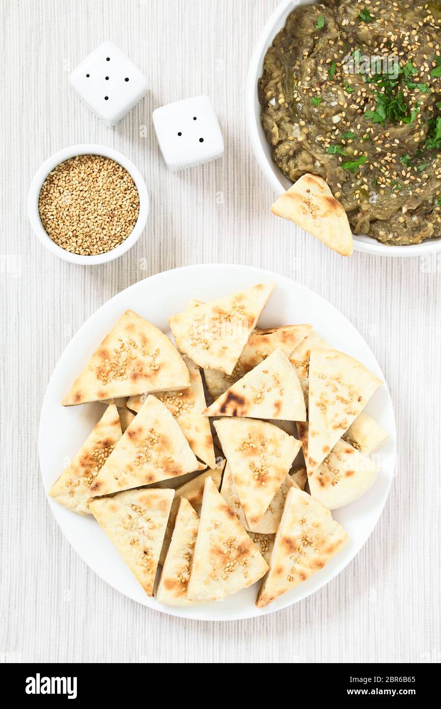 Hausgemachte Sesam pita Chips mit gebratenen Auberginen dip oder verbreiten, Baba ganoush in die mediterrane Küche an der Seite, fotografiert Overhead mit Natu Stockfoto