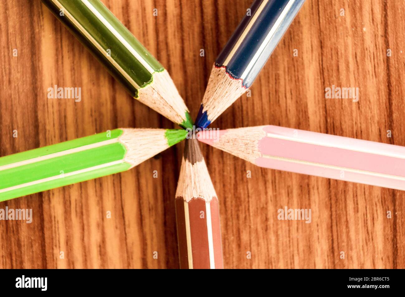 Symbolisches Bild zentrale Macht treffen an einem Punkt. Nahaufnahme einer Auswahl von Buntstiften, die in einem Kreis wie CO angeordnet sind Stockfoto