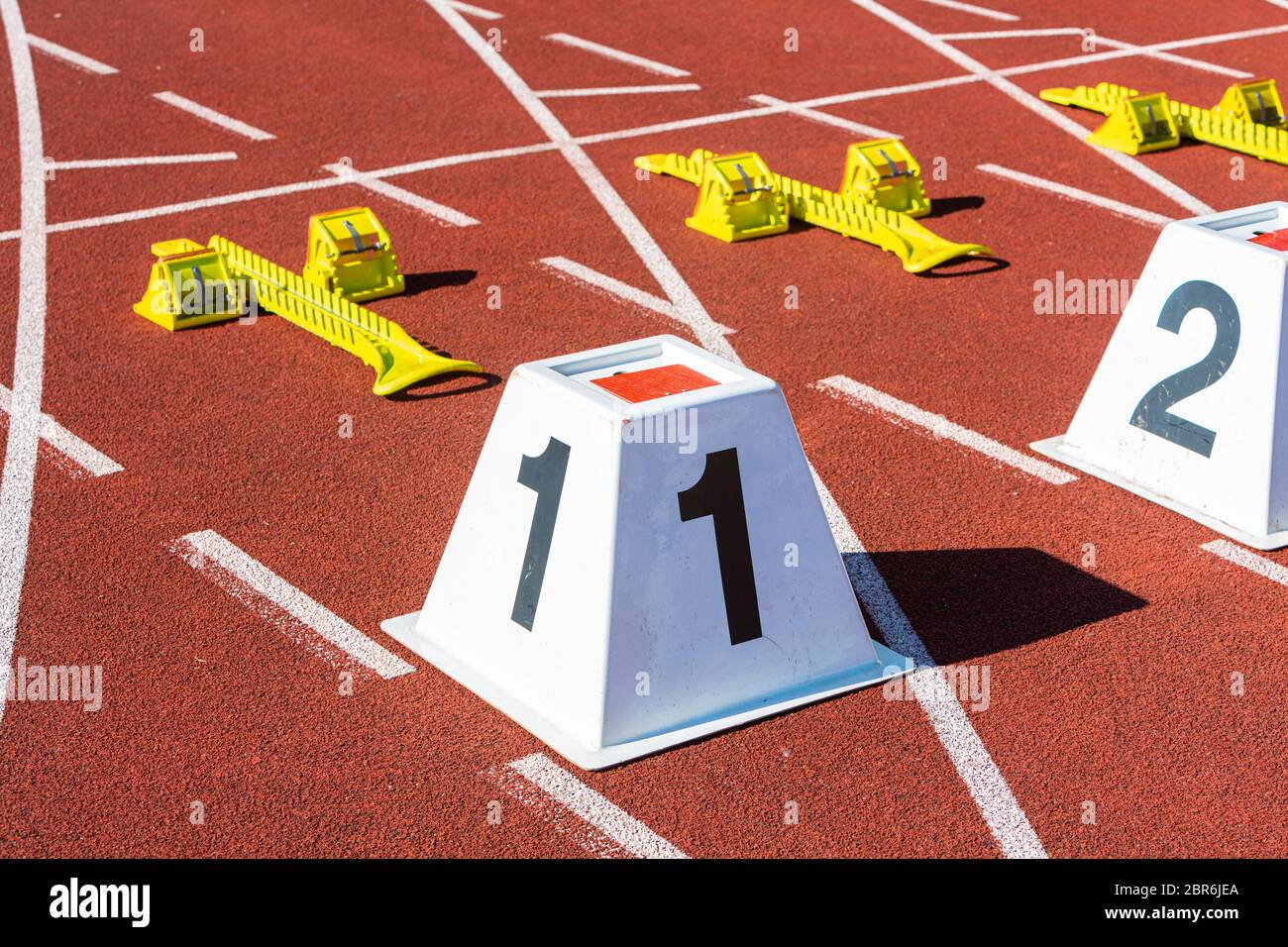 Sprint-Startlinie im Sportstadion mit den Zahlen eins und zwei Stockfoto