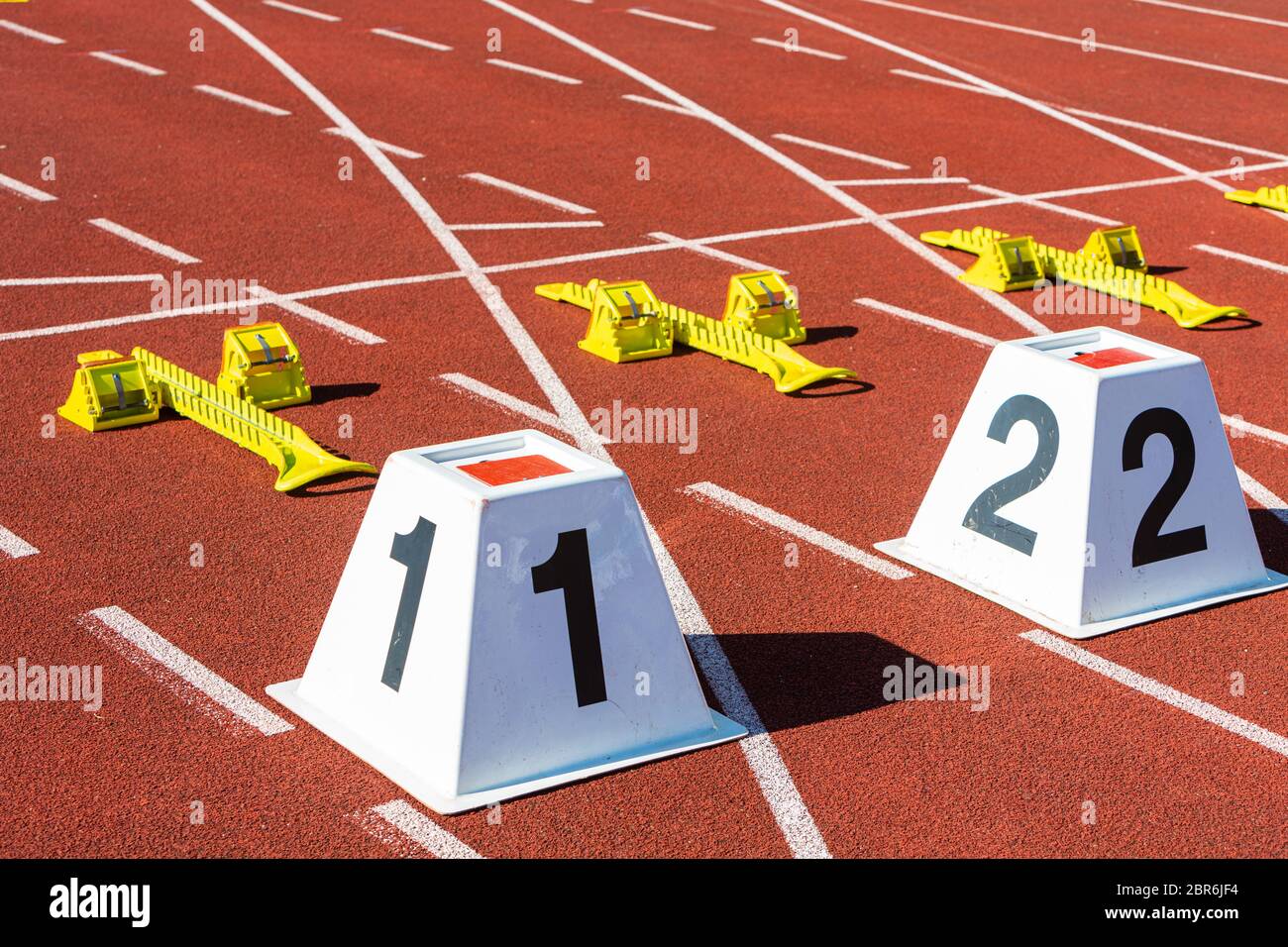 Sprint-Startlinie im Sportstadion mit den Zahlen eins und zwei Stockfoto