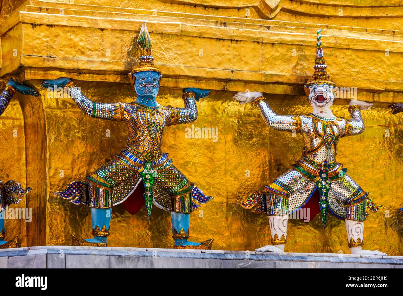 Schöne riesige Statuen an der Basis der Goldene Pagode in Wat Pra Keo im Grand Palace in Bangkok ab. Stockfoto