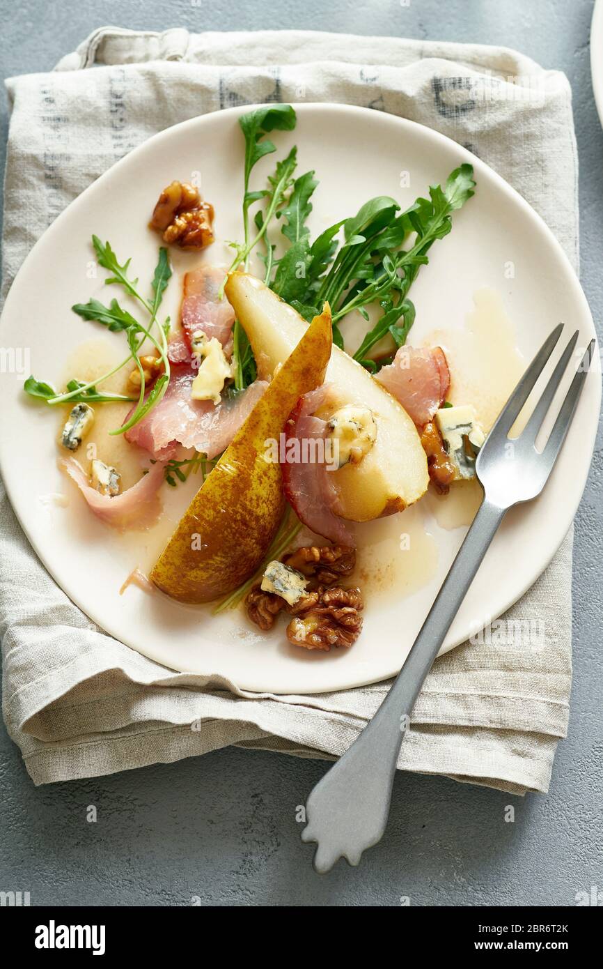 Birnensalat mit Walnüssen, Prosciutto, Rucola und Blauschimmelkäse. Abendessen Vorspeise Stockfoto