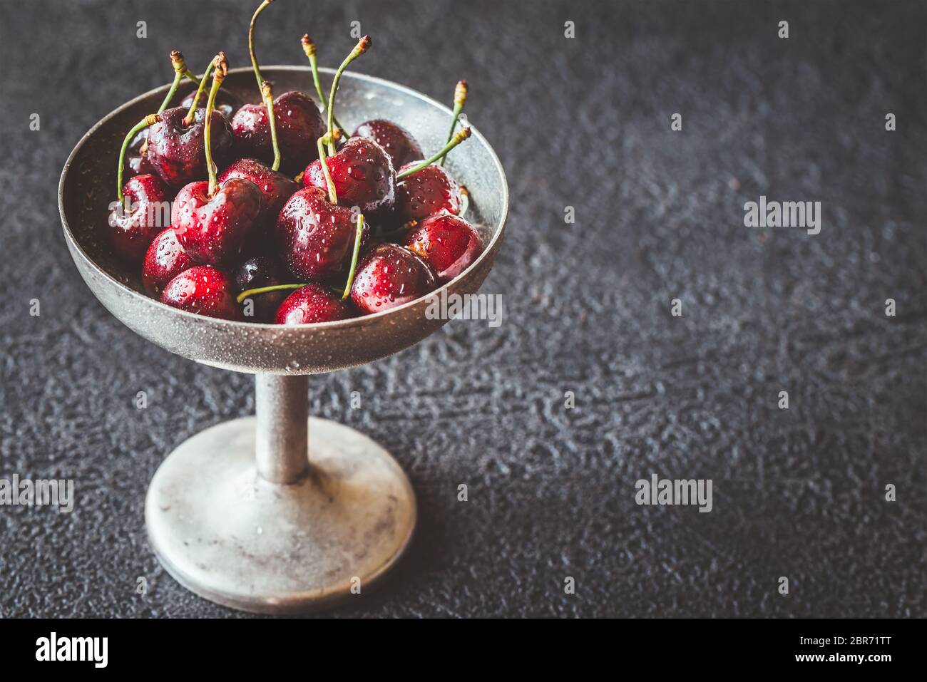 Frische Kirschen in Vintage silver Vase auf dem dunklen Hintergrund Stockfoto