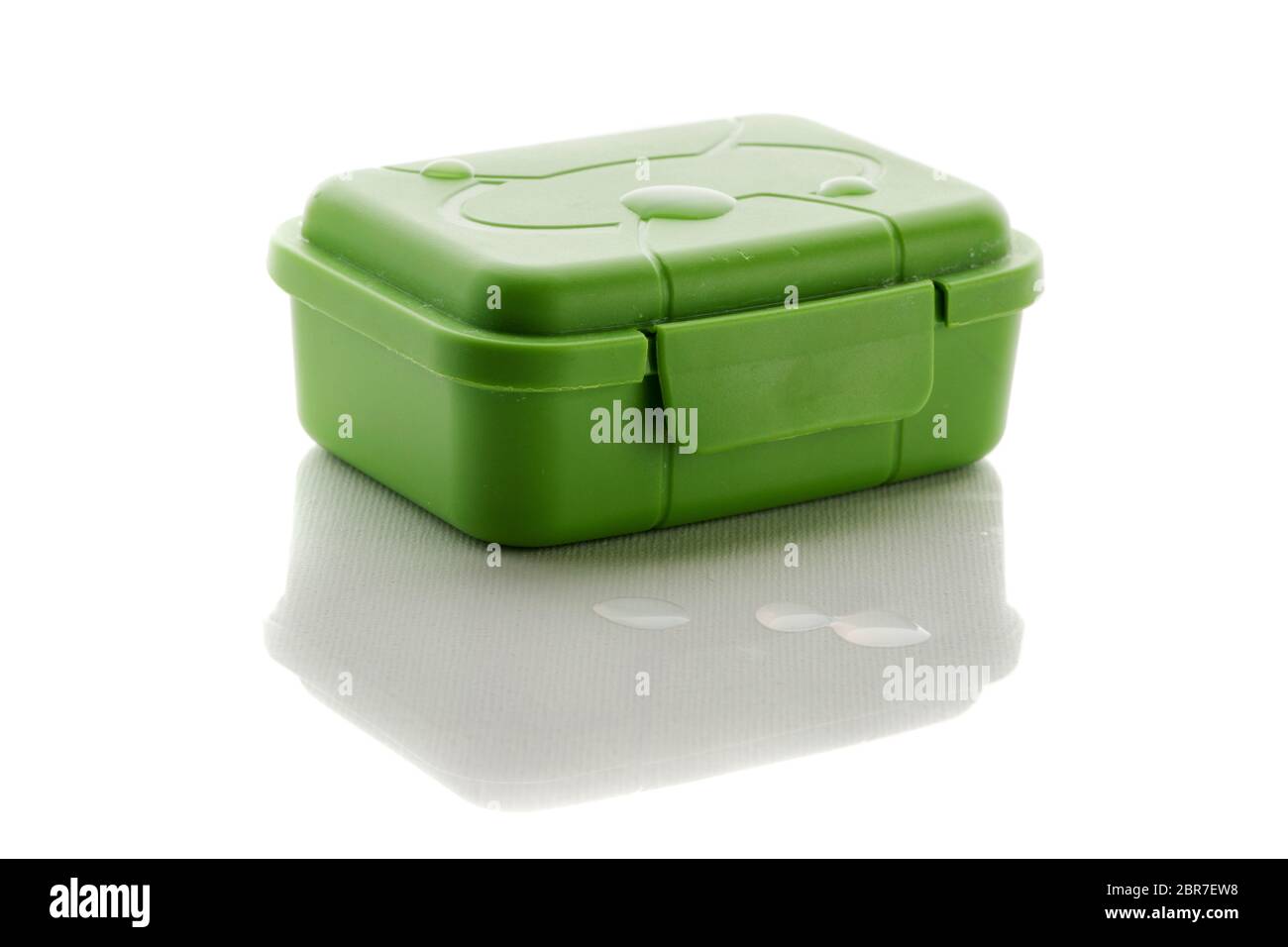 Geschlossene grüne Seifenbox mit drei Tropfen Wasser auf der Dose und davor isoliert auf weiß mit Reflexion. Stockfoto