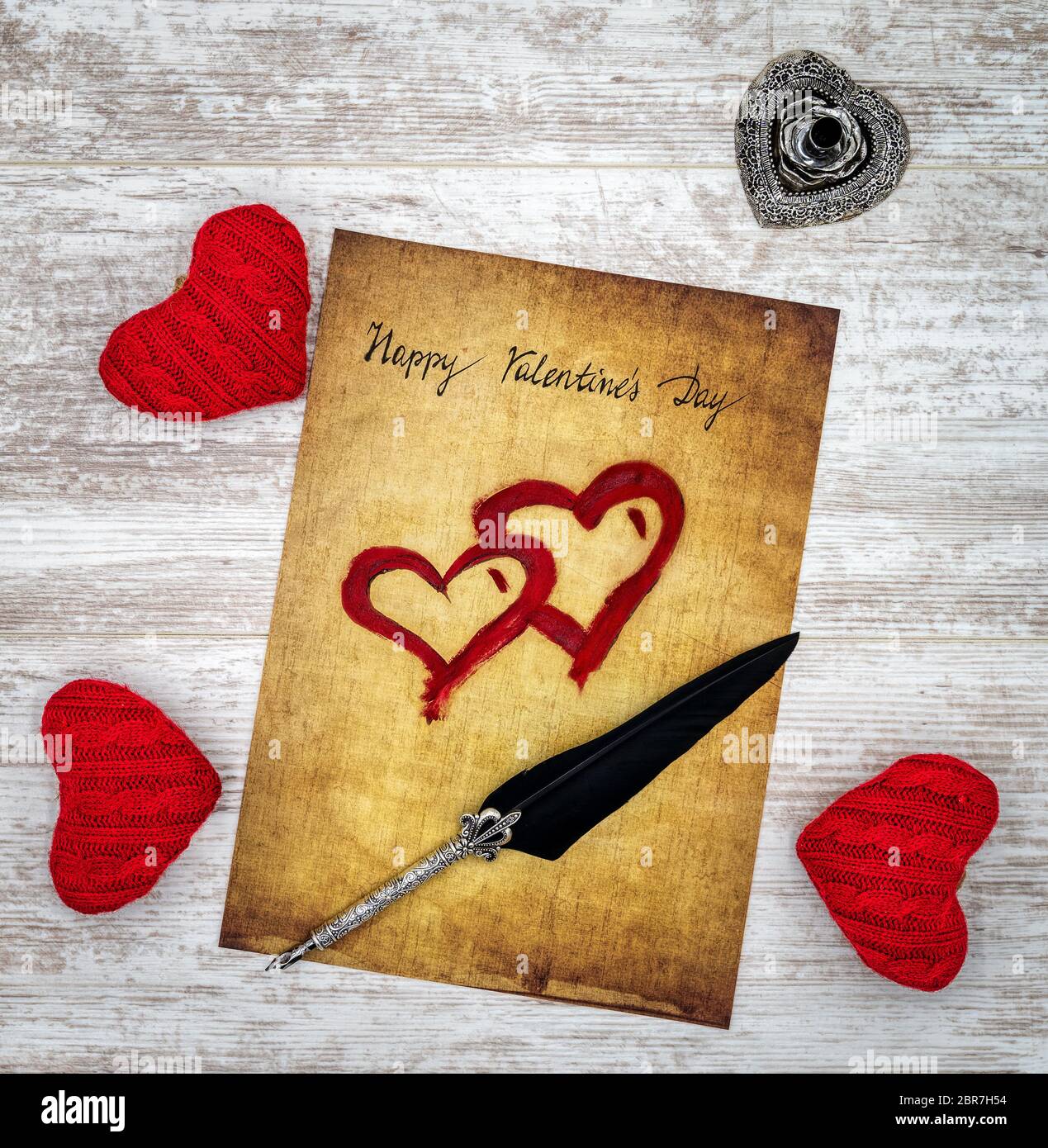Antike Vorlösung mit handgeschriebener Happy Valentines Day, 3 rote Kuschelherz, rot bemalte Herzen, detailreiche silberne Kiel-Ständer in Form von hart, ornam Stockfoto
