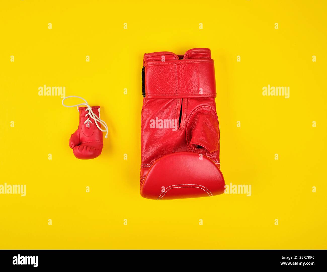Zwei roten Boxhandschuhen auf gelbem Hintergrund, Konzept der Unterschied Stockfoto