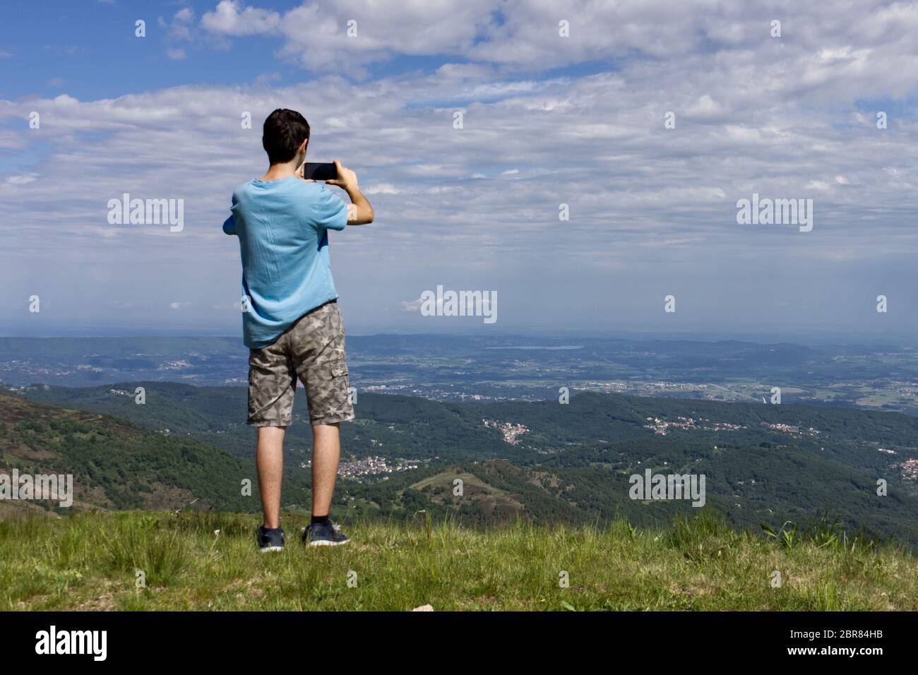 Ein Typ nimmt ein Landschaftsbild mit seinem Handy von einem Aussichtspunkt Stockfoto