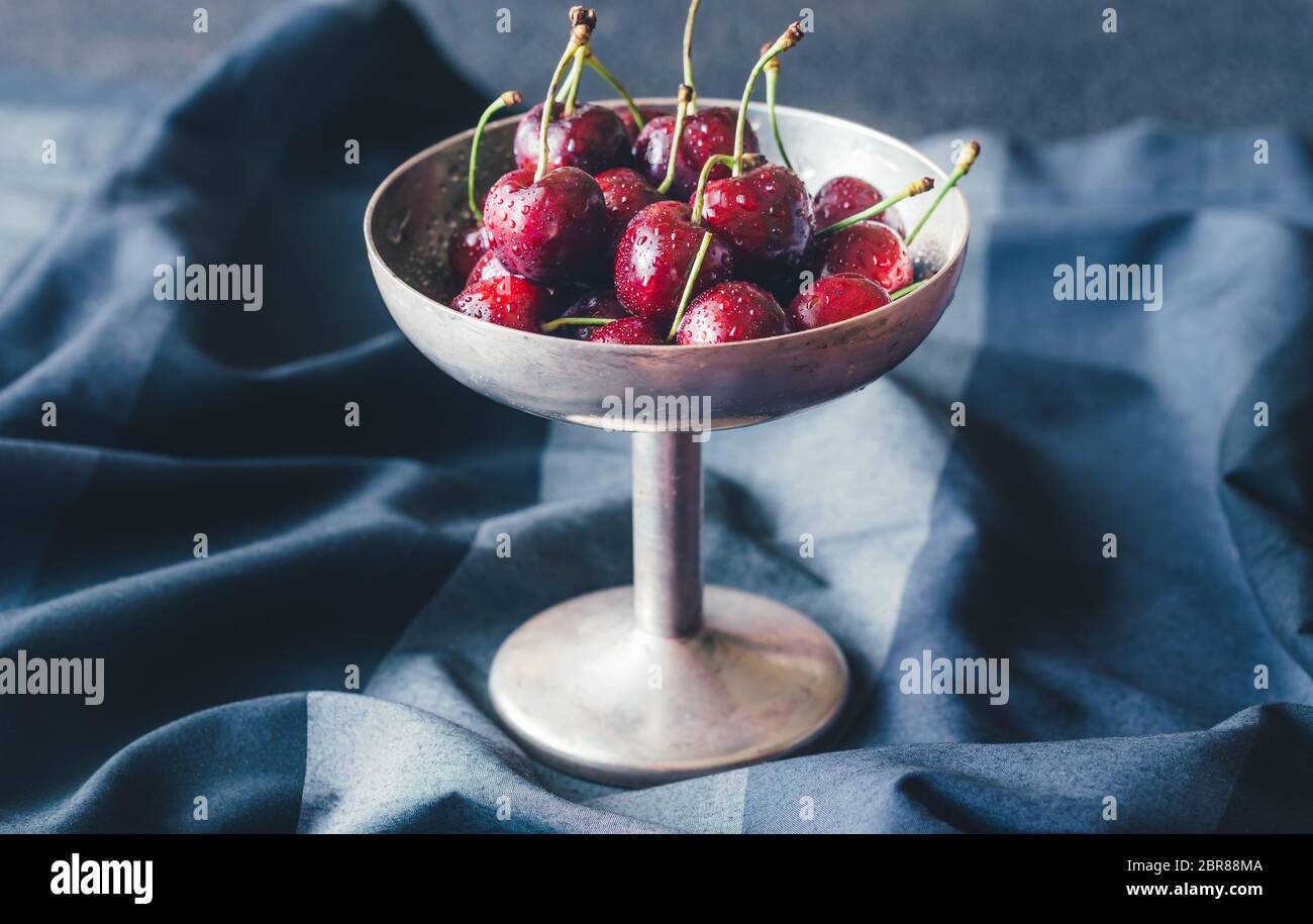 Frische Kirschen in Vintage silver Vase auf dem dunklen Hintergrund Stockfoto