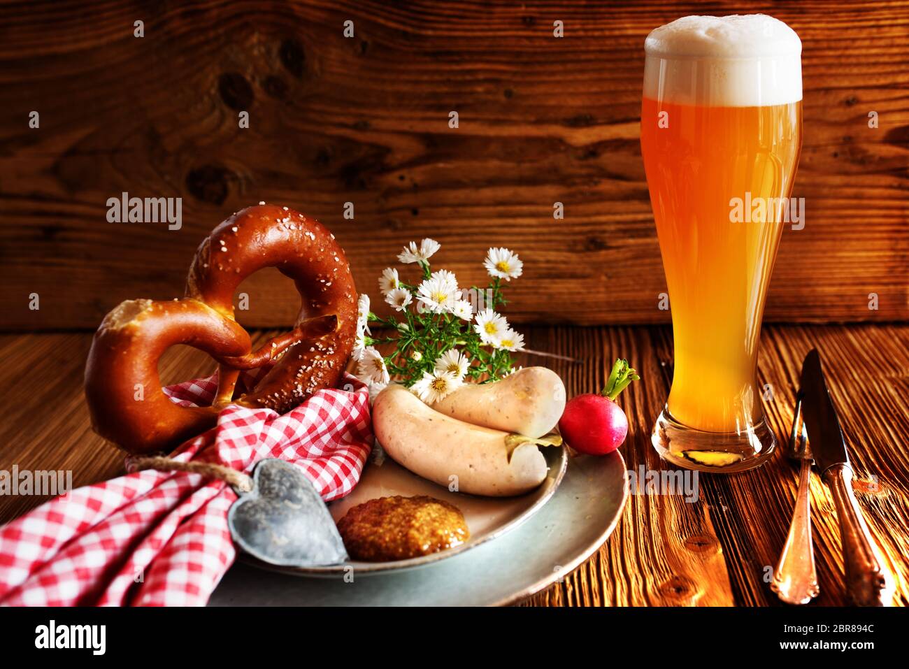 Bayerische Spezialitäten frisches Bier mit Salzbrezel und Weißwurst auf rustikalem Holz zum Oktoberfest Stockfoto