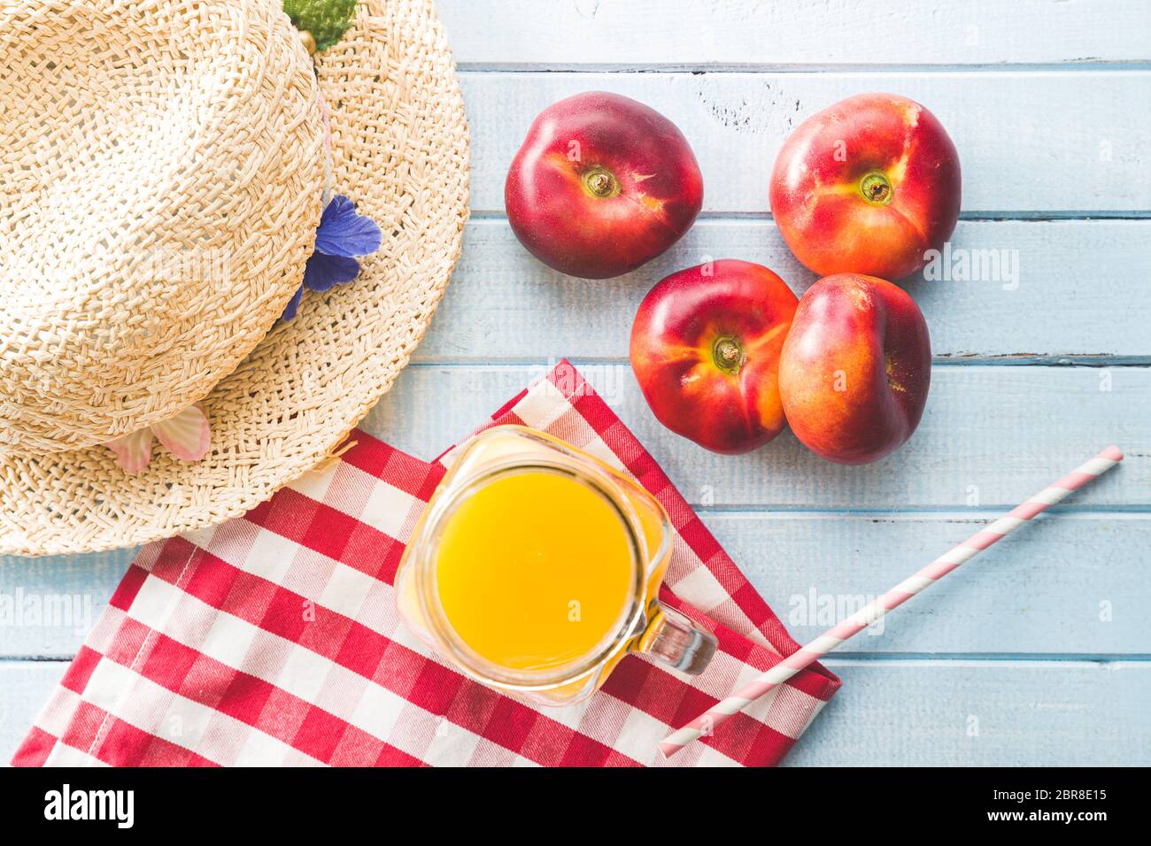 Reife flache Nektarinen und Saft auf blauem Tisch. Draufsicht. Stockfoto