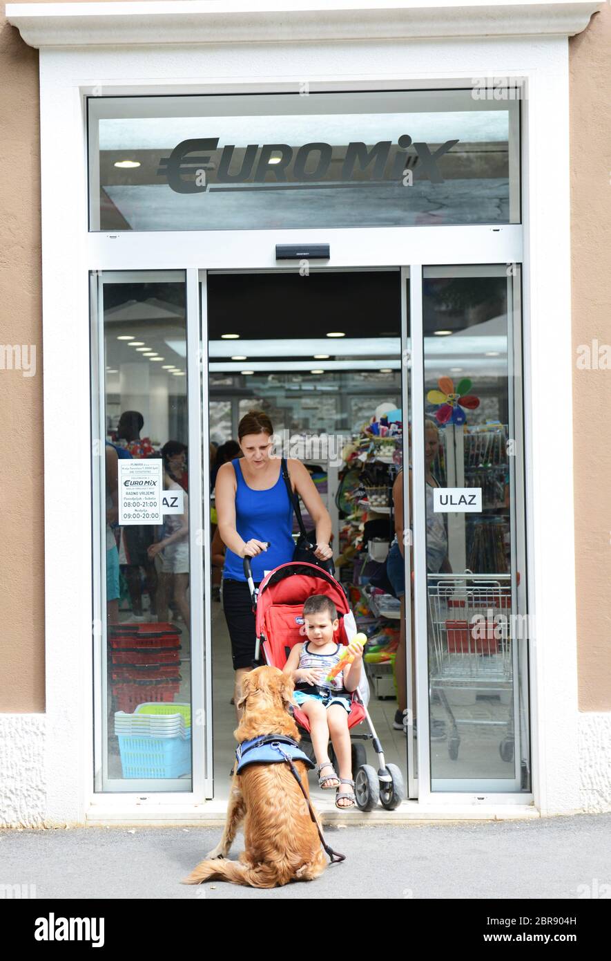 Eine kroatische Frau mit ihrem Jungen und Haustier Hund. Stockfoto