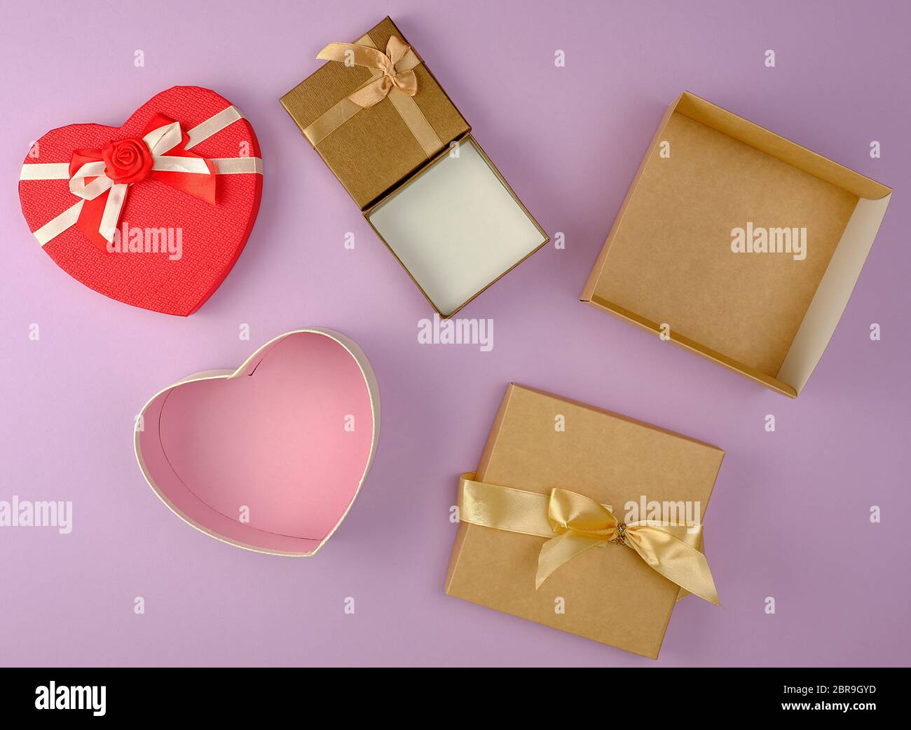 Verschiedene leere offene Papier Geschenkboxen auf lila Hintergrund, Ansicht von oben, festliche Kulisse Stockfoto