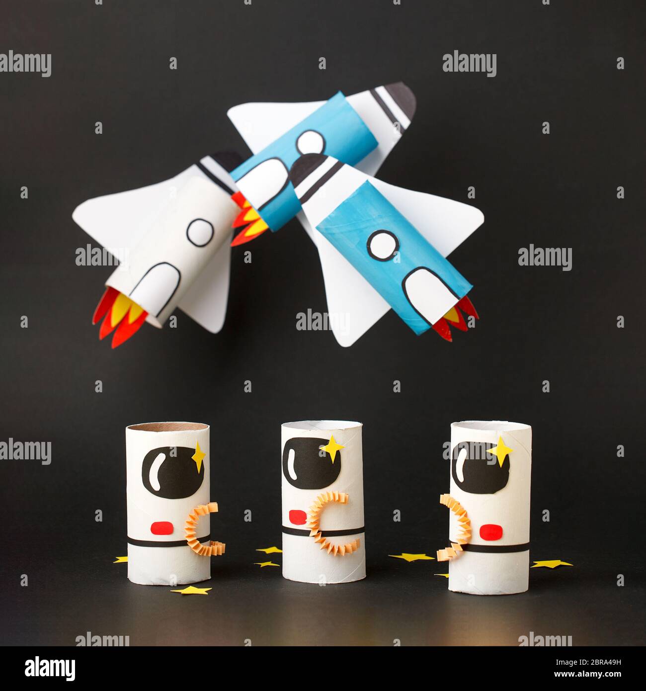 Schule Kindergarten Handwerk, Papier Raumschiff, Shuttle, Astronaut auf schwarzem Hintergrund mit Kopierraum für Text. Party, Start up Launch Konzept, diy, cre Stockfoto