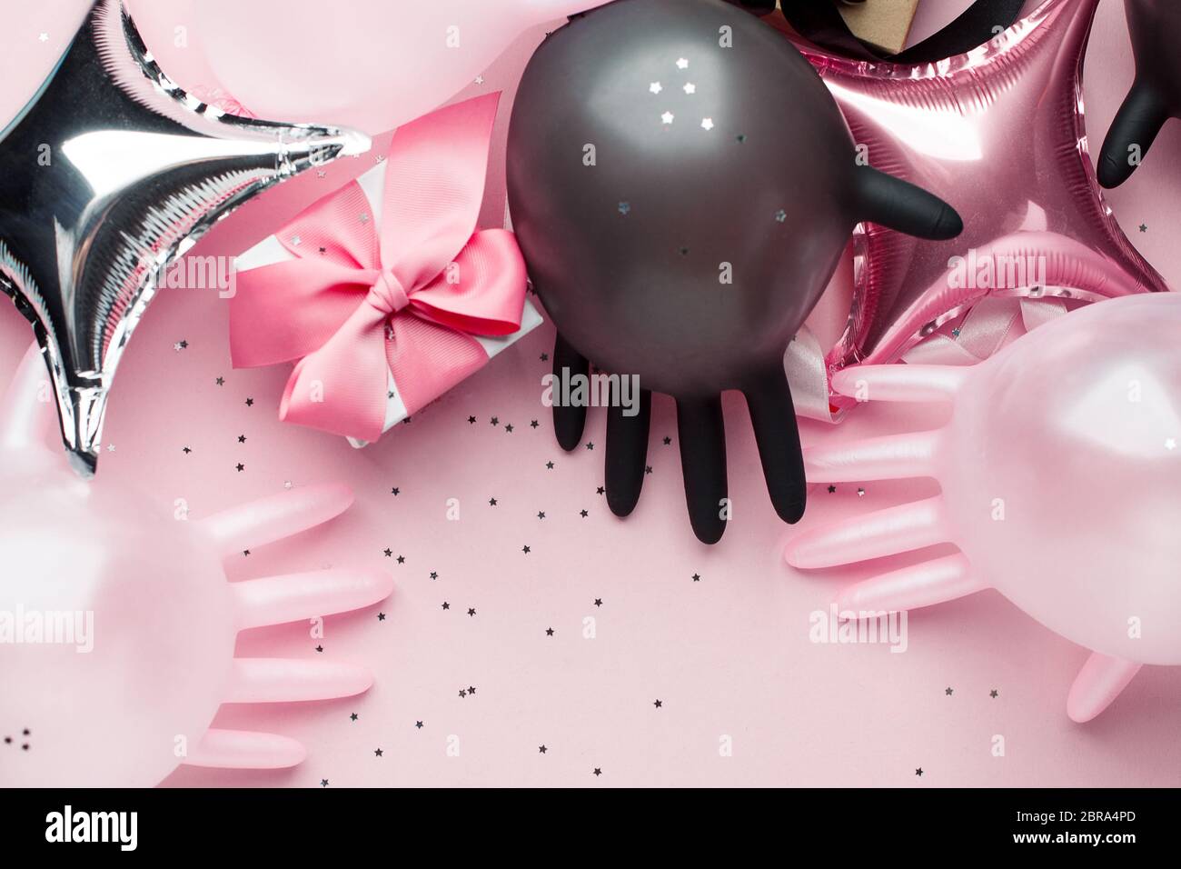 Creative Concept Geschenkbox, Party-Dekor und medizinische Handschuhe als Luftballon auf rosa Hintergrund mit Kopierraum. Luxus-Mode, Shopping Pandemie Verkauf CO Stockfoto