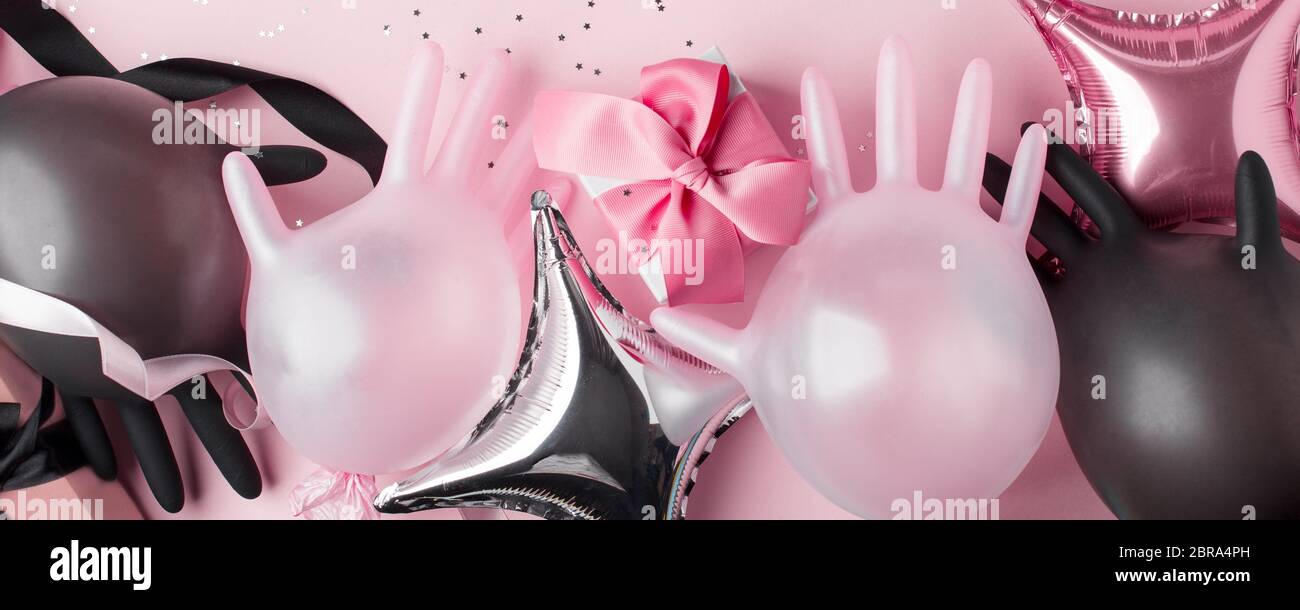 Creative Concept Geschenkbox, Party-Dekor und medizinische Handschuhe als Luftballon auf rosa Hintergrund. Luxus-Mode, Shopping Pandemie Verkauf Konzept. Hochzeit, Stockfoto