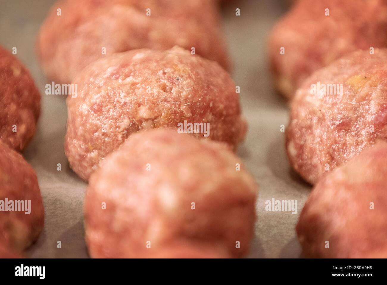Rohe Knödel auf Tablett. Leckeres Hackfleisch in Form von Kugeln mit Pfeffer, Salz. Weiche Konzentration. Stockfoto