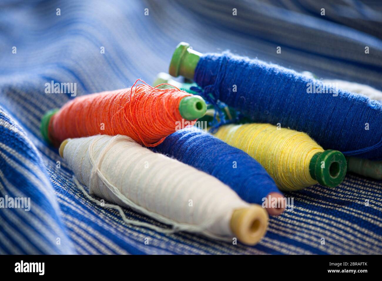 Spulen aus Baumwollfäden auf Textilmaterial, die in einer Kooperative in Oaxaca, Mexiko, auf einem Webstuhl webt wurden. Stockfoto