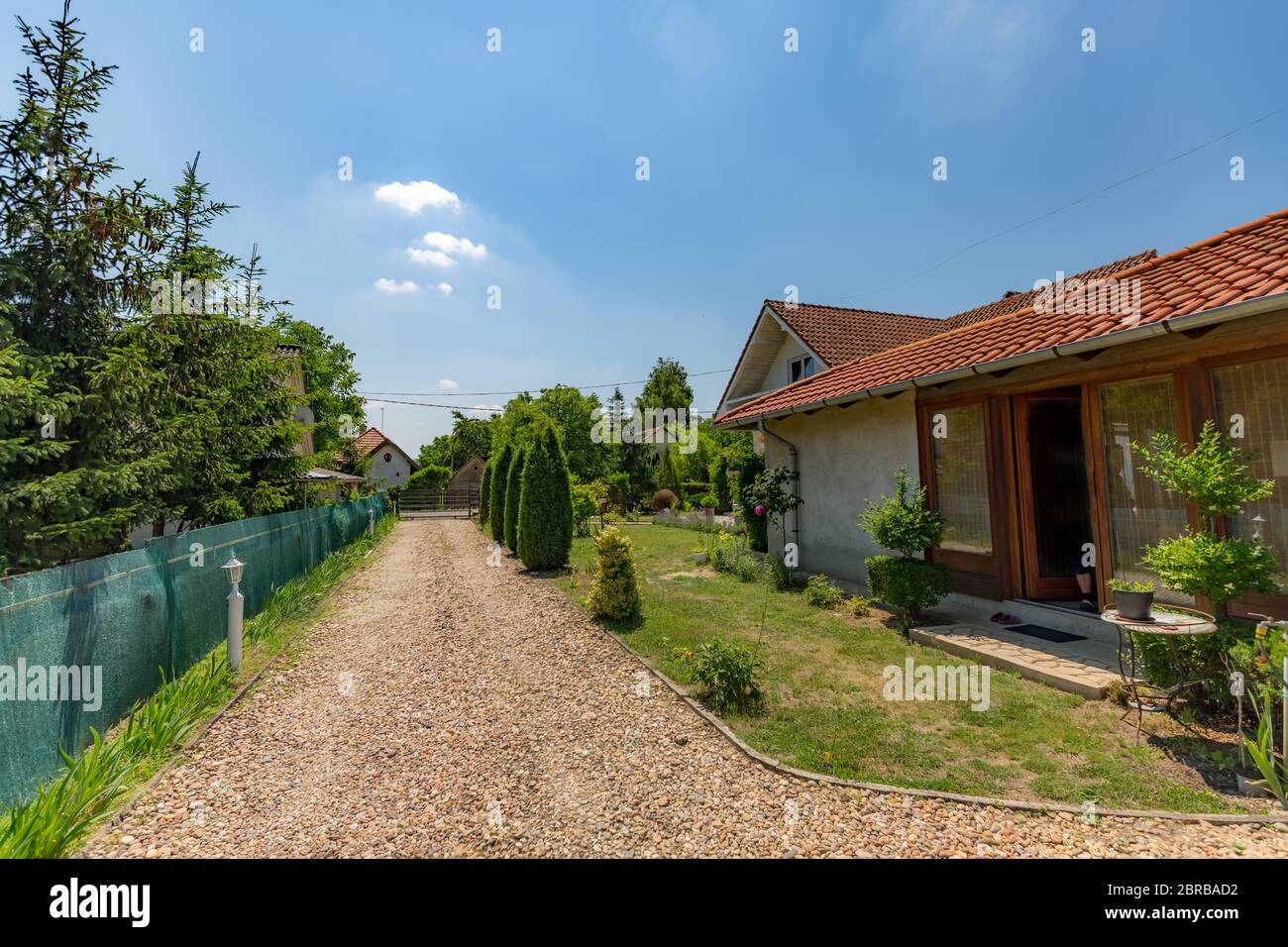 Englisches Landhaus, Auffahrt und grüner Zaun in der Nähe des Nachbarn Stockfoto