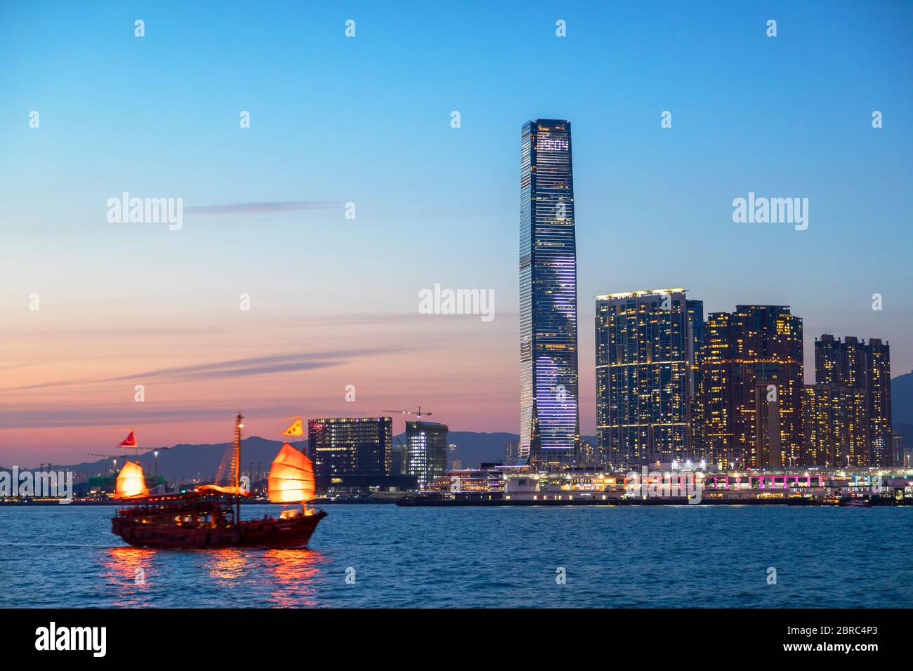 International Commerce Centre (ICC) und Junk Boat bei Sonnenuntergang, Hongkong Stockfoto