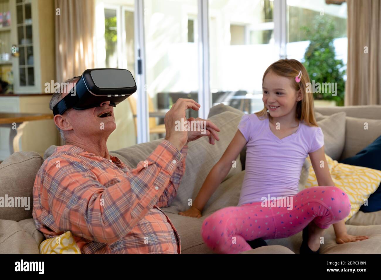 Großvater und Enkelin zu Hause im Wohnzimmer Stockfoto