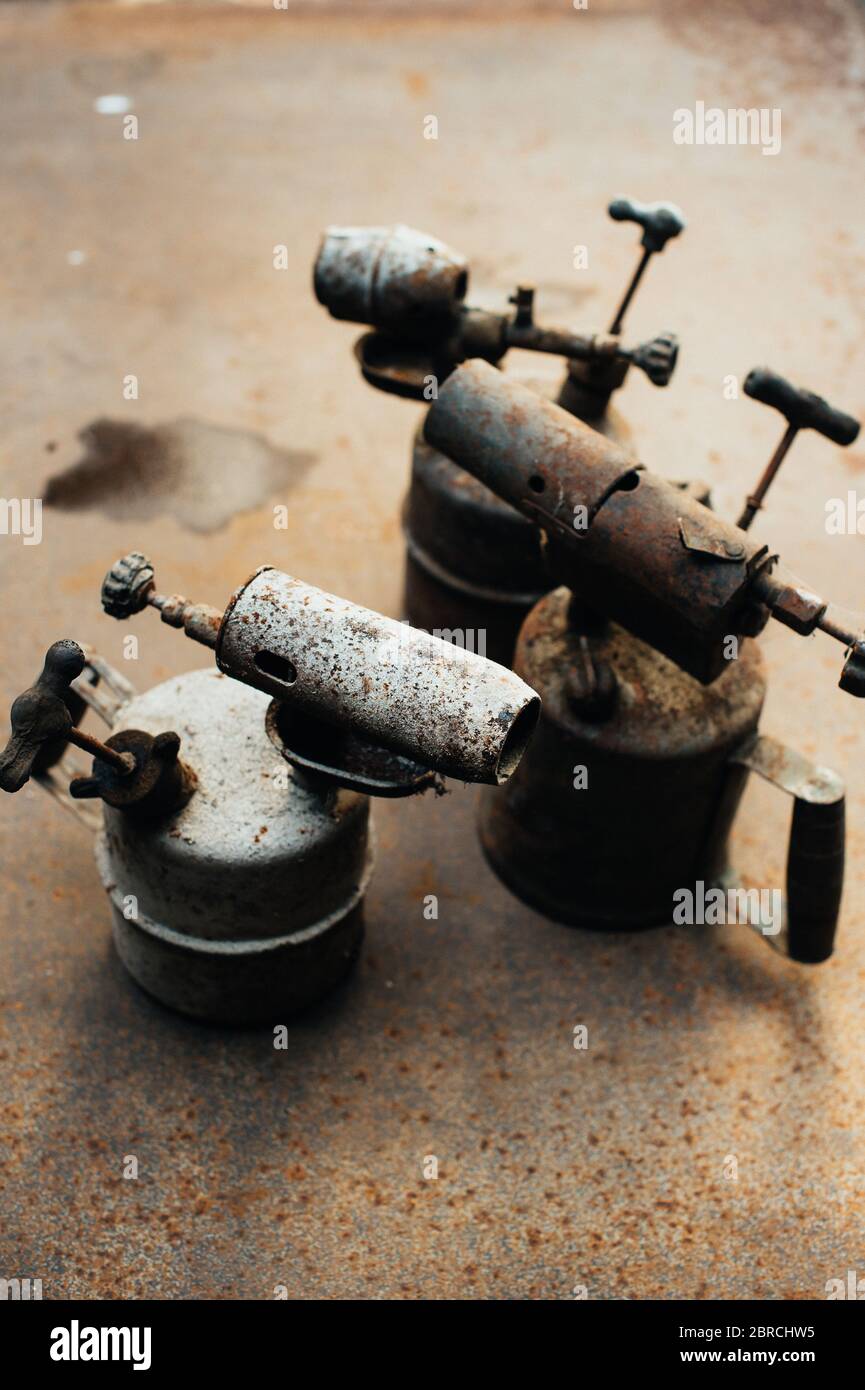 Alte rostige Gasbrenner steht auf einem rostigen Eisenblech. Metallschrott. Nahaufnahme. Stockfoto