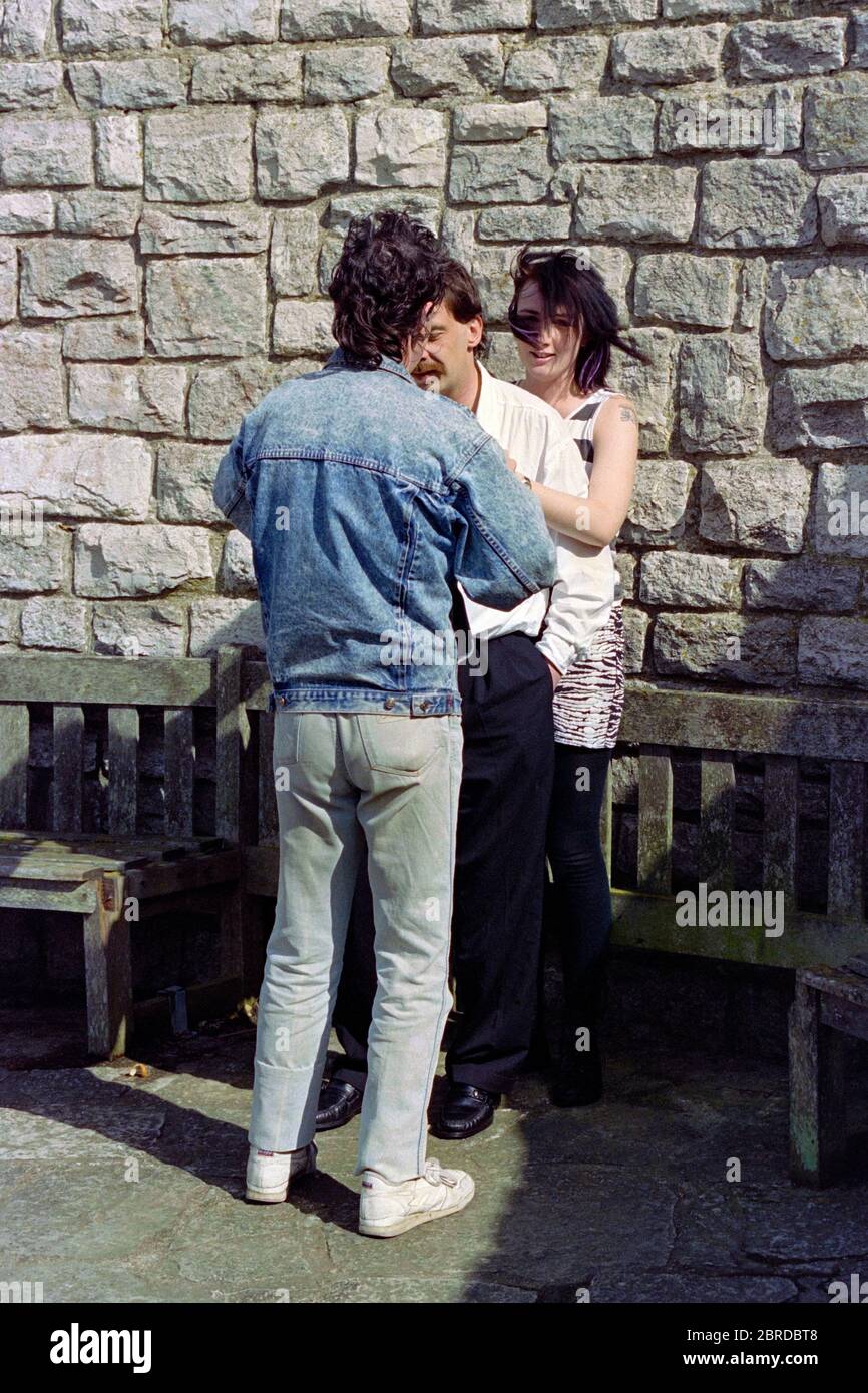 Junger männlicher Fotograf, der zwei Modelle bei einem Fotoshooting in den frühen 1990er jahren arrangiert england großbritannien Stockfoto