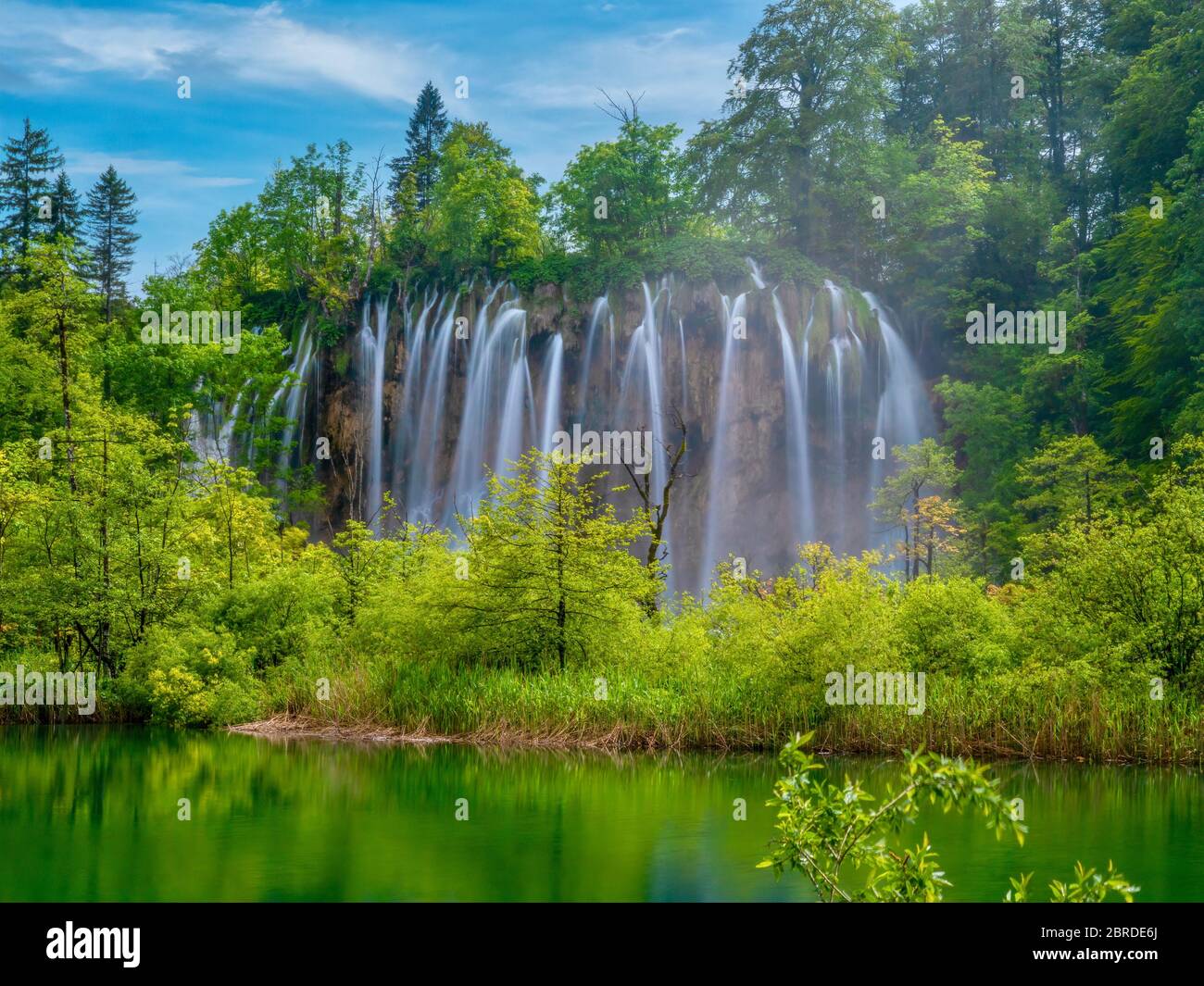 Lange Exposition von einer schönen Reihe von Wasserfällen im pulsierenden grünen Wald des Nationalparks Plitvicer Seen, Kroatien. Stockfoto