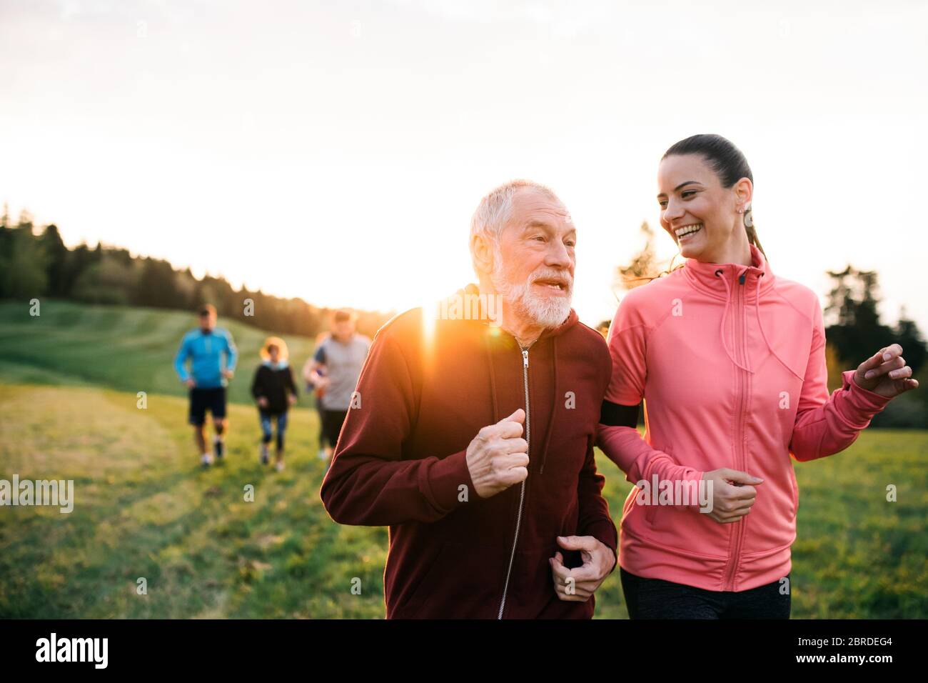 Große Gruppe von Menschen laufen im Land bei Sonnenuntergang. Stockfoto