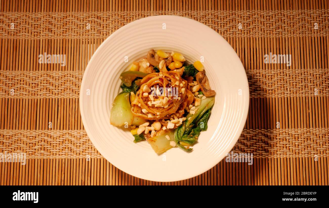 DAN DAN GLUTENFREIE NUDELN MIT MAIS, PAK CHOY, PILZE, CAPSICUM, ZWIEBELN, SPINAT Stockfoto