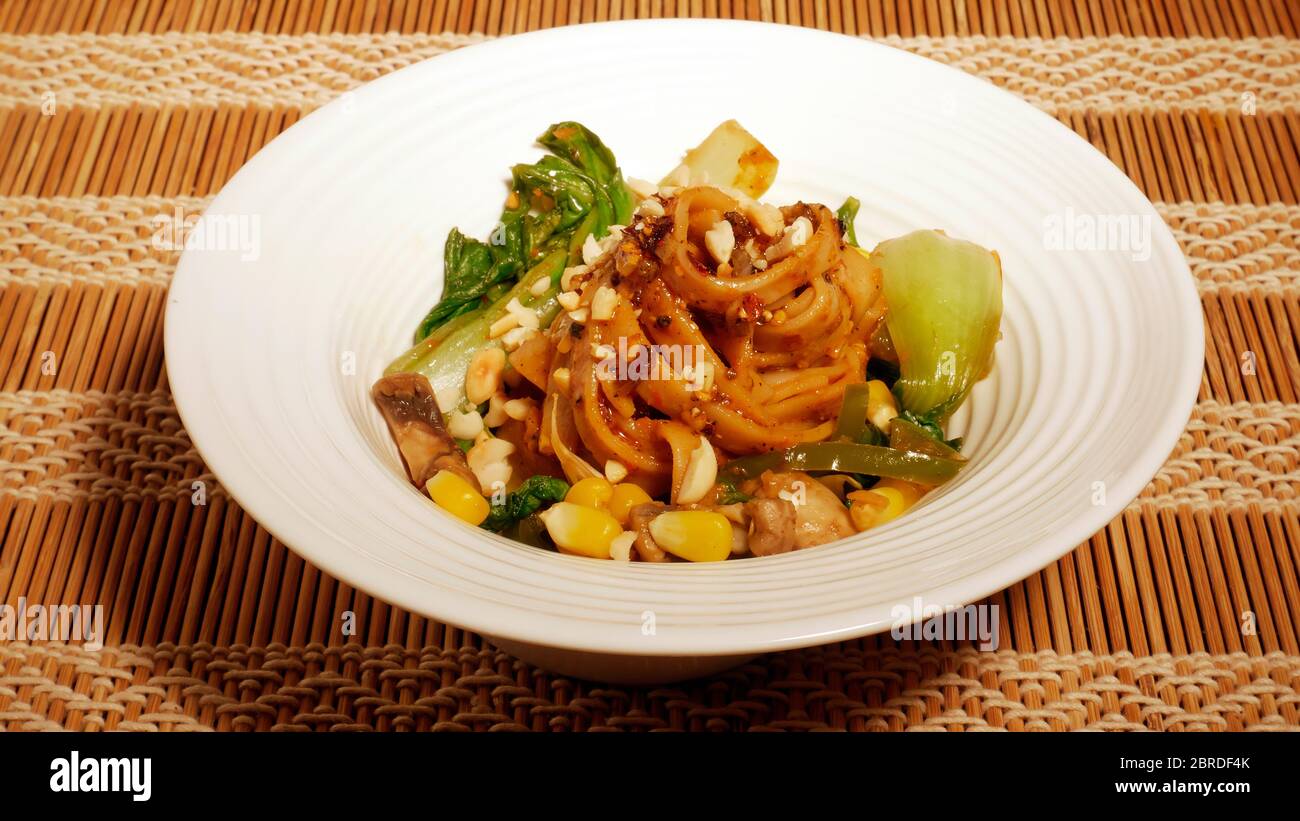 DAN DAN GLUTENFREIE NUDELN MIT MAIS, PAK CHOY, PILZE, CAPSICUM, ZWIEBELN, SPINAT Stockfoto