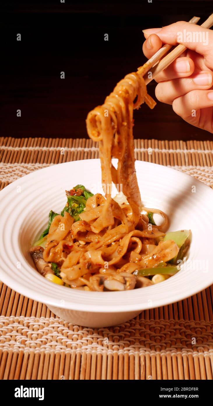 DAN DAN GLUTENFREIE NUDELN MIT MAIS, PAK CHOY, PILZE, CAPSICUM, ZWIEBELN, SPINAT Stockfoto