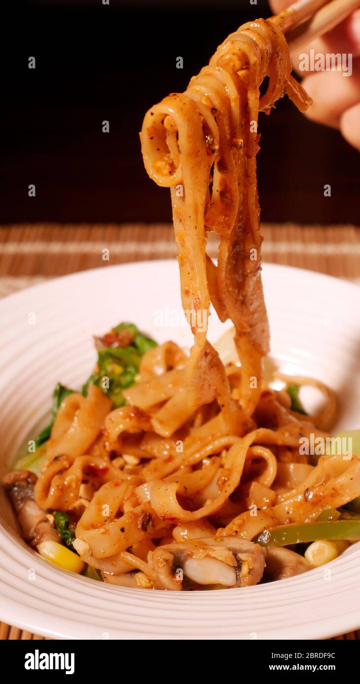 DAN DAN GLUTENFREIE NUDELN MIT MAIS, PAK CHOY, PILZE, CAPSICUM, ZWIEBELN, SPINAT Stockfoto