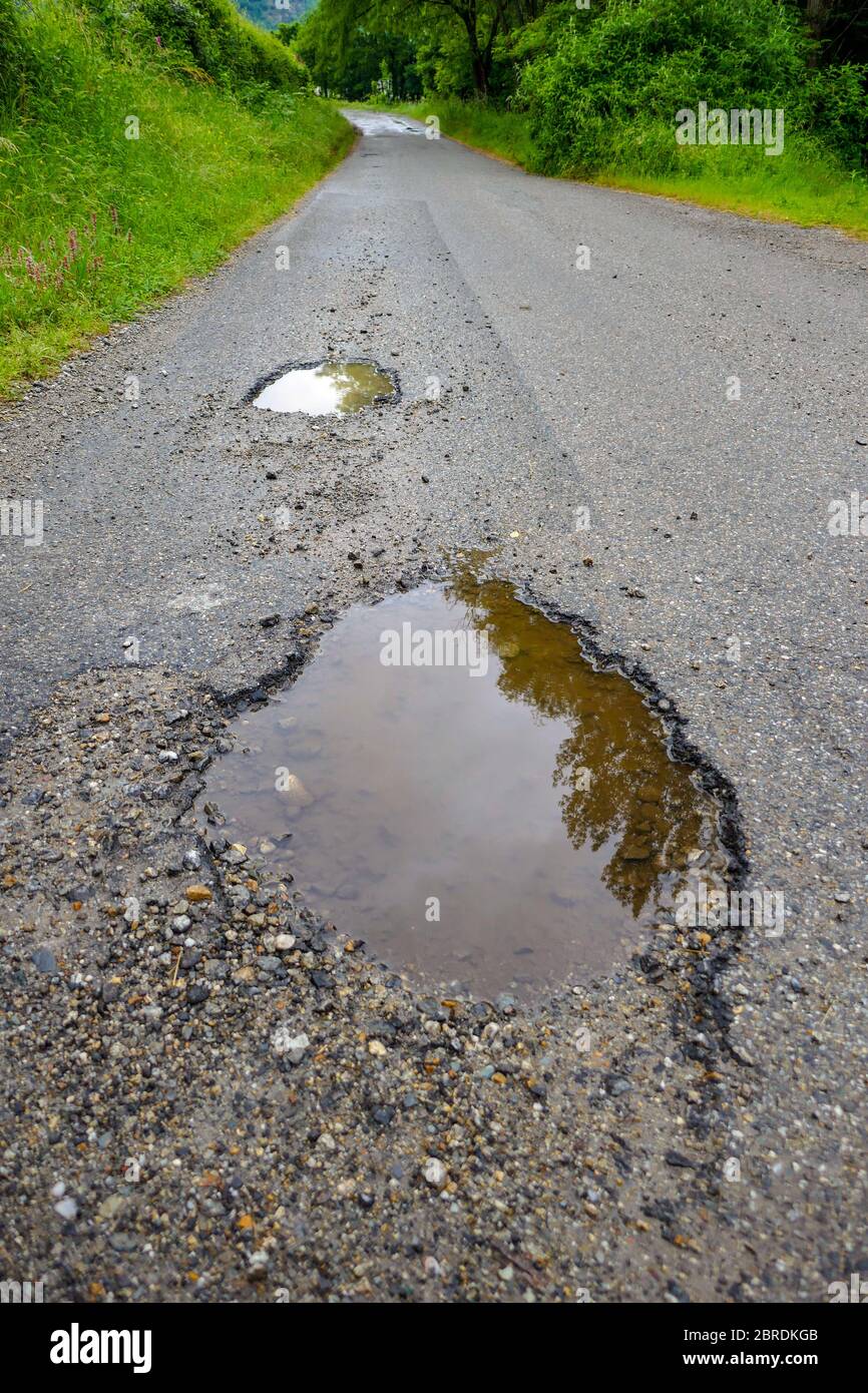 Schlagloch und Pfütze auf der Fahrbahn, Ariege, französische Pyrenäen, Pyrenäen, Frankreich Stockfoto