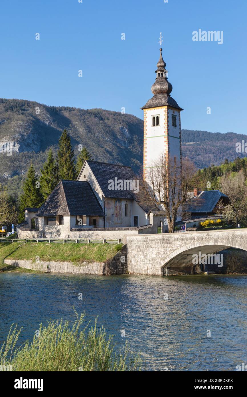 Die romanisch-gotische Kirche des Hl. Johannes des Täufers wurde um 1100 am Ufer des Bohinjer Sees außerhalb von Ribcev Laz, Oberkrain, Slowenien, erbaut. Stockfoto