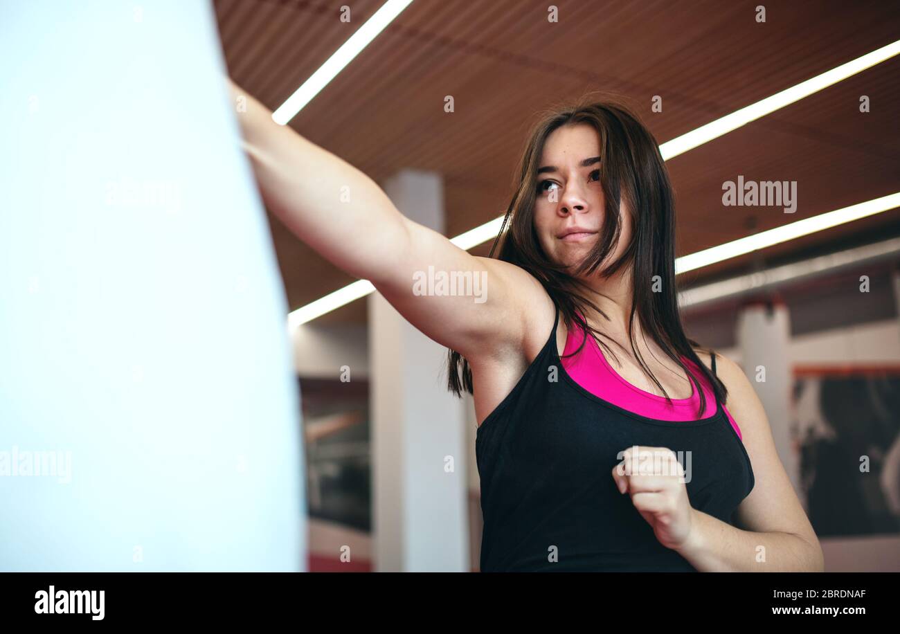Eine junge Frau, die im Fitnessstudio Karate praktiziert. Kopierbereich. Stockfoto