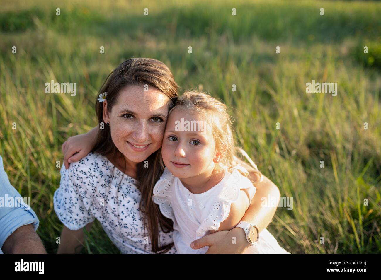 Mutter mit kleinem Kleinkind Tochter auf Spaziergang auf Wiese im Freien. Stockfoto