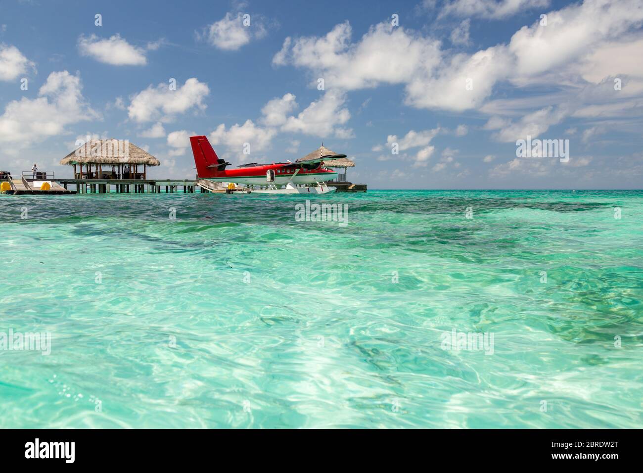 Wasserflugzeug auf den Malediven. Wunderschöne blaue Lagune, mit rotem Wasserflugzeug. Luxus Reise und Sommerurlaub Konzept Stockfoto
