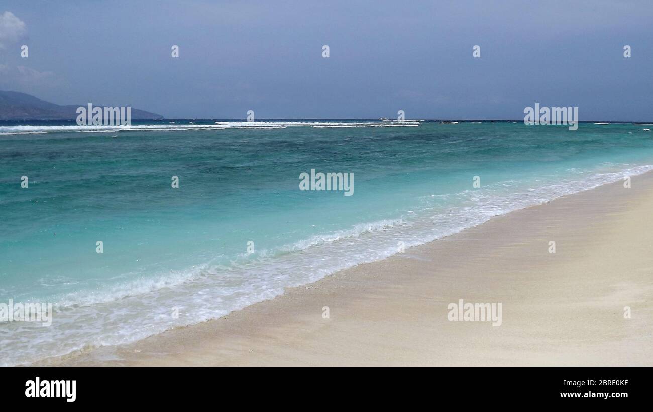 Wunderschönes blaues Meer und tropischer weißer Sandstrand an sonnigen Sommertagen. Toller Meerblick mit azurblauem Kristallwasser. Landschaftlich bewölkten Himmel im Hintergrund. Bis Stockfoto