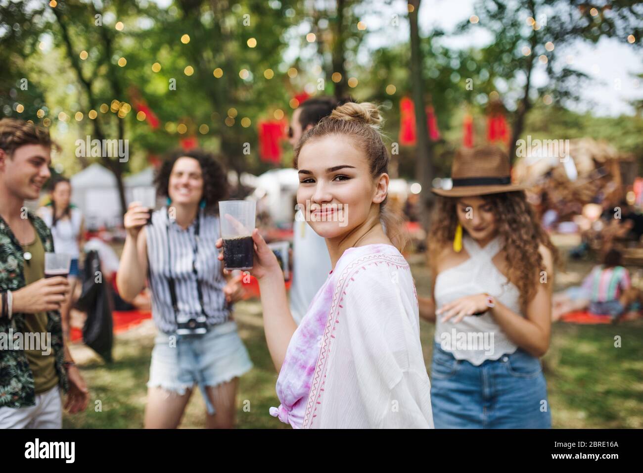 Gruppe von jungen Freunden mit Getränken beim Sommerfest, stehend. Stockfoto