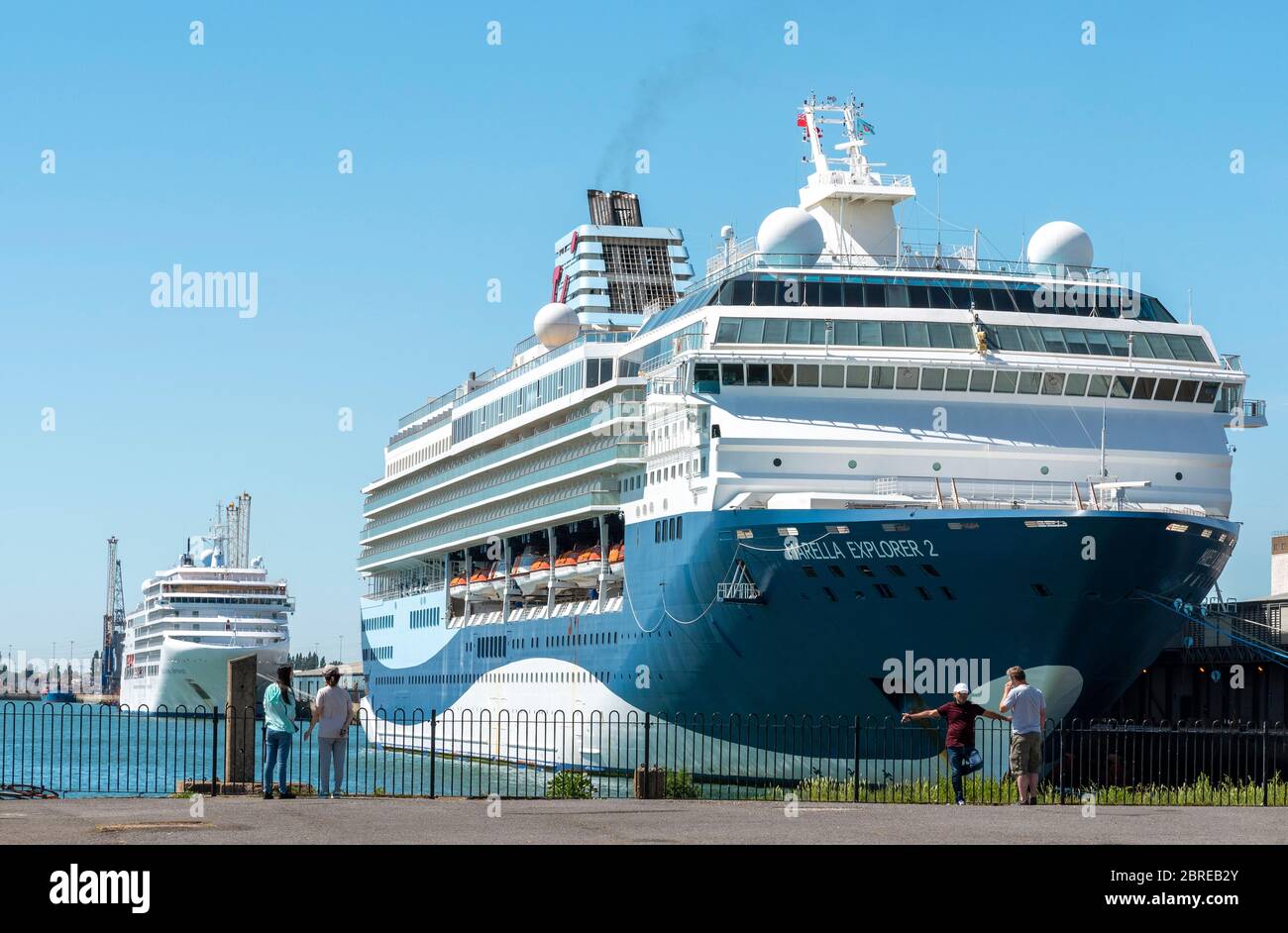 Southampton, England, Großbritannien. Mai 2020. Menschen auf dem Kai während der Coronavirus Sperrzeit mit zwei Kreuzfahrtschiffen neben im Hafen von S Stockfoto