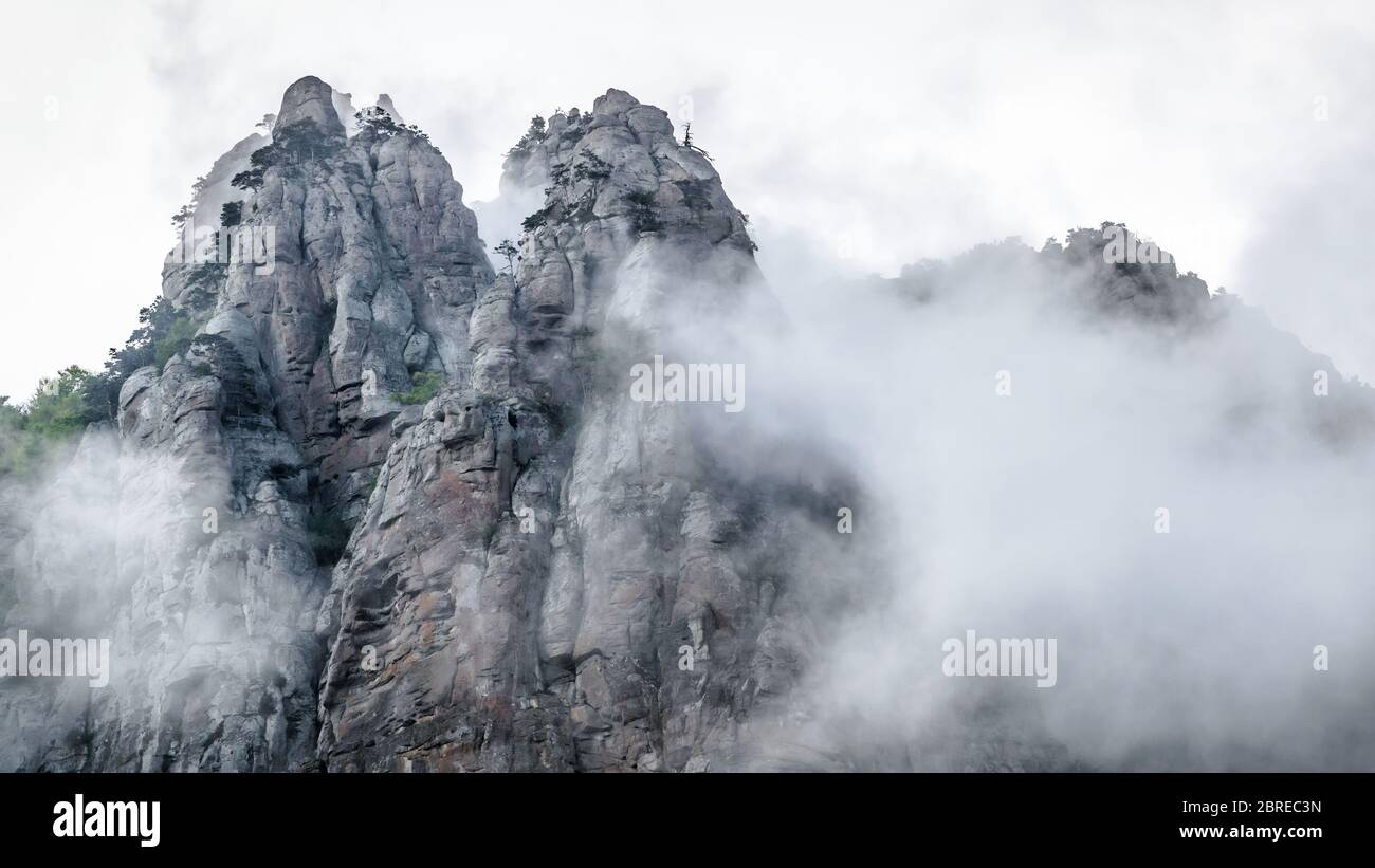 Berglandschaft mit niedrigen Wolken oder Nebel, Krim, Russland. Panorama des nebeligen Demerdji Berges. Dieser Ort ist eine natürliche touristische Attraktion Krim. Stockfoto