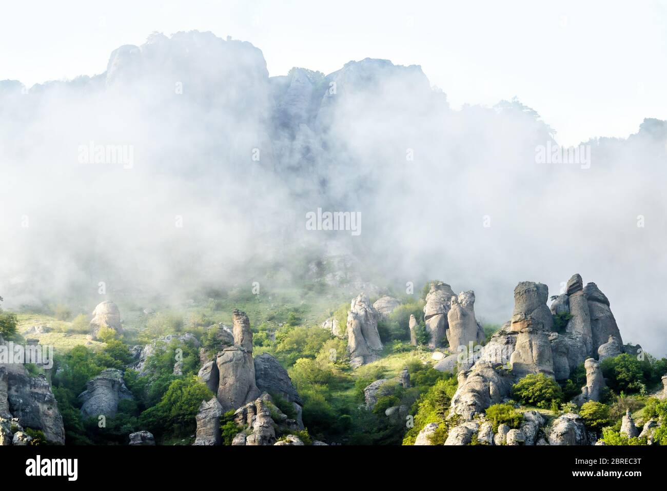 Nebeliger Berg in Krim, Russland. Landschaftlich schöne Aussicht auf das Tal des Geistes. Landschaft von bizarren nebligen Felsen im Sommer. Berglandschaft mit tief liegendem Clou Stockfoto