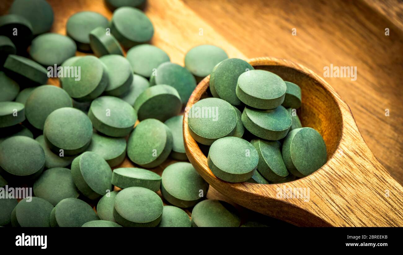Grüne Algen in Tabletten - Chlorella, Spirulina in Holzlöffel auf  Holzhintergrund - Nahaufnahme Stockfotografie - Alamy