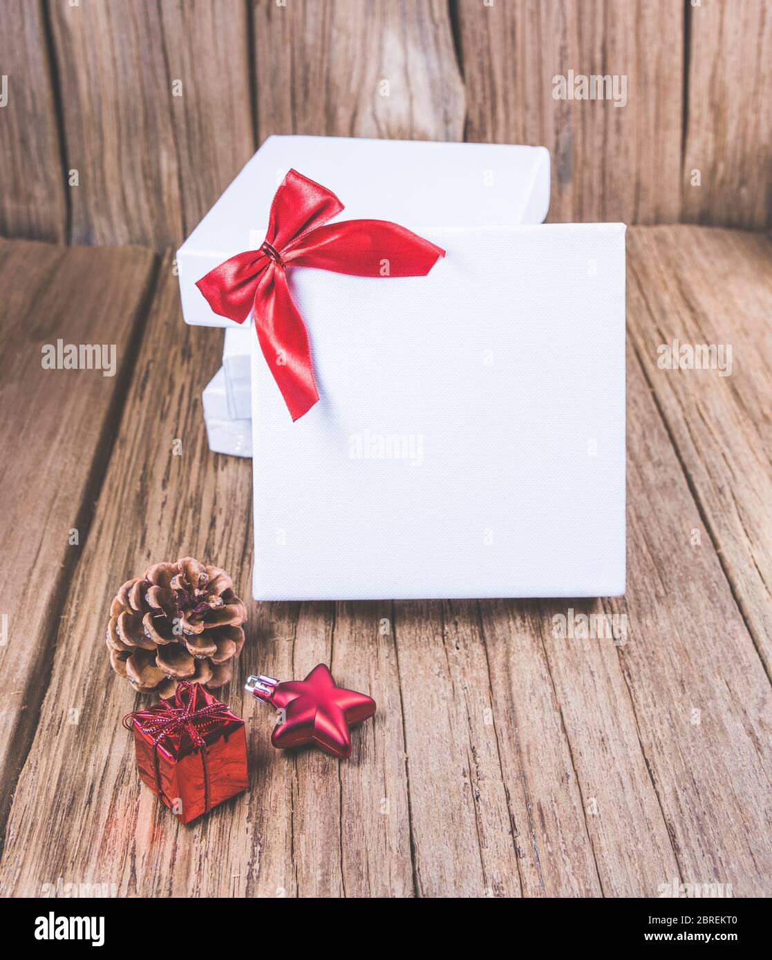 Weiße Leinwand Raum Rahmen mit Weihnachtsschmuck auf Holzplatte, bereit für Produktdisplay Montage. Stockfoto