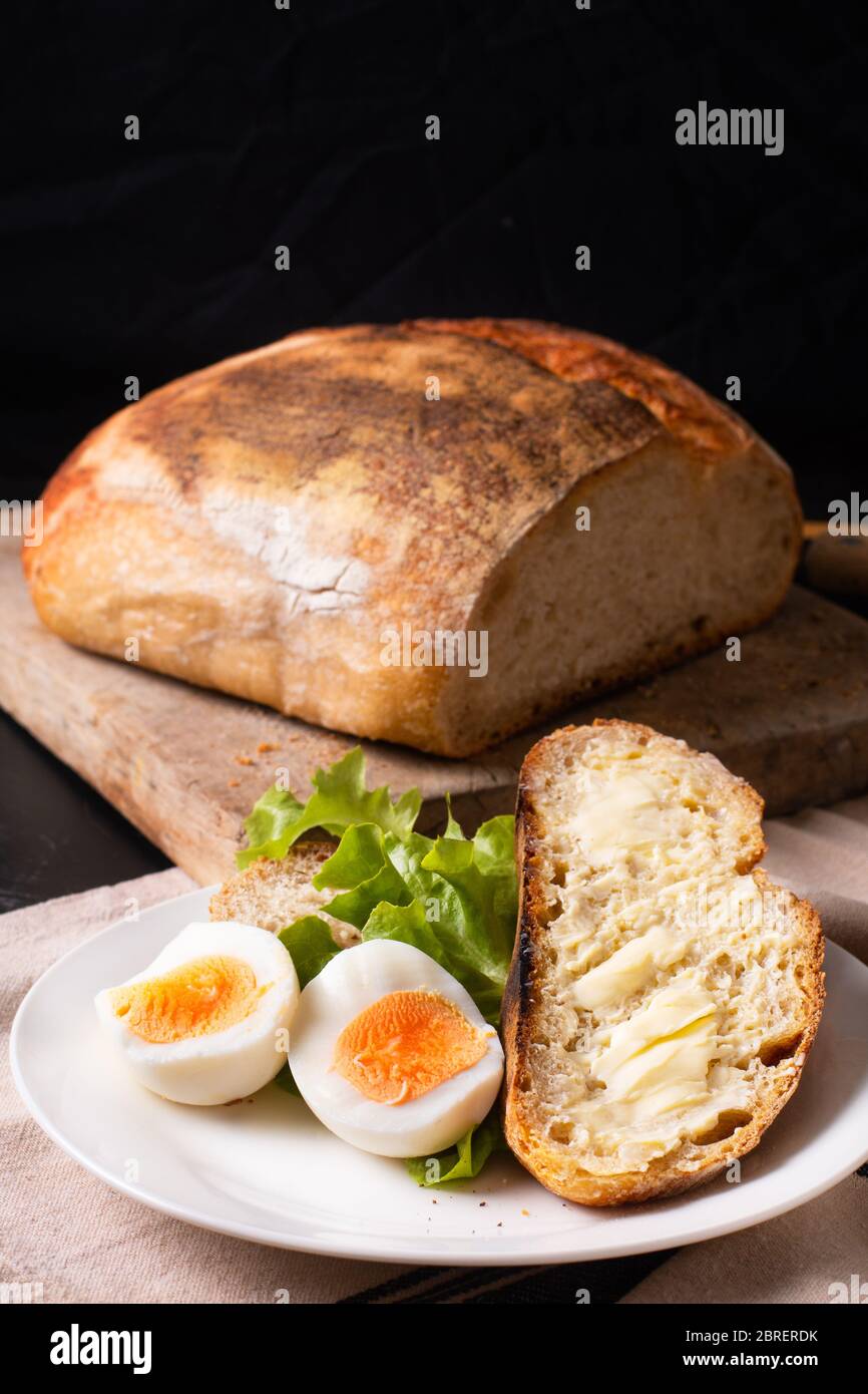 Gesundes Essen Food Konzept hausgemachte Bio-Sauerteig Brot und gekochtes Ei in weißen Teller mit Kopierer Raum Stockfoto