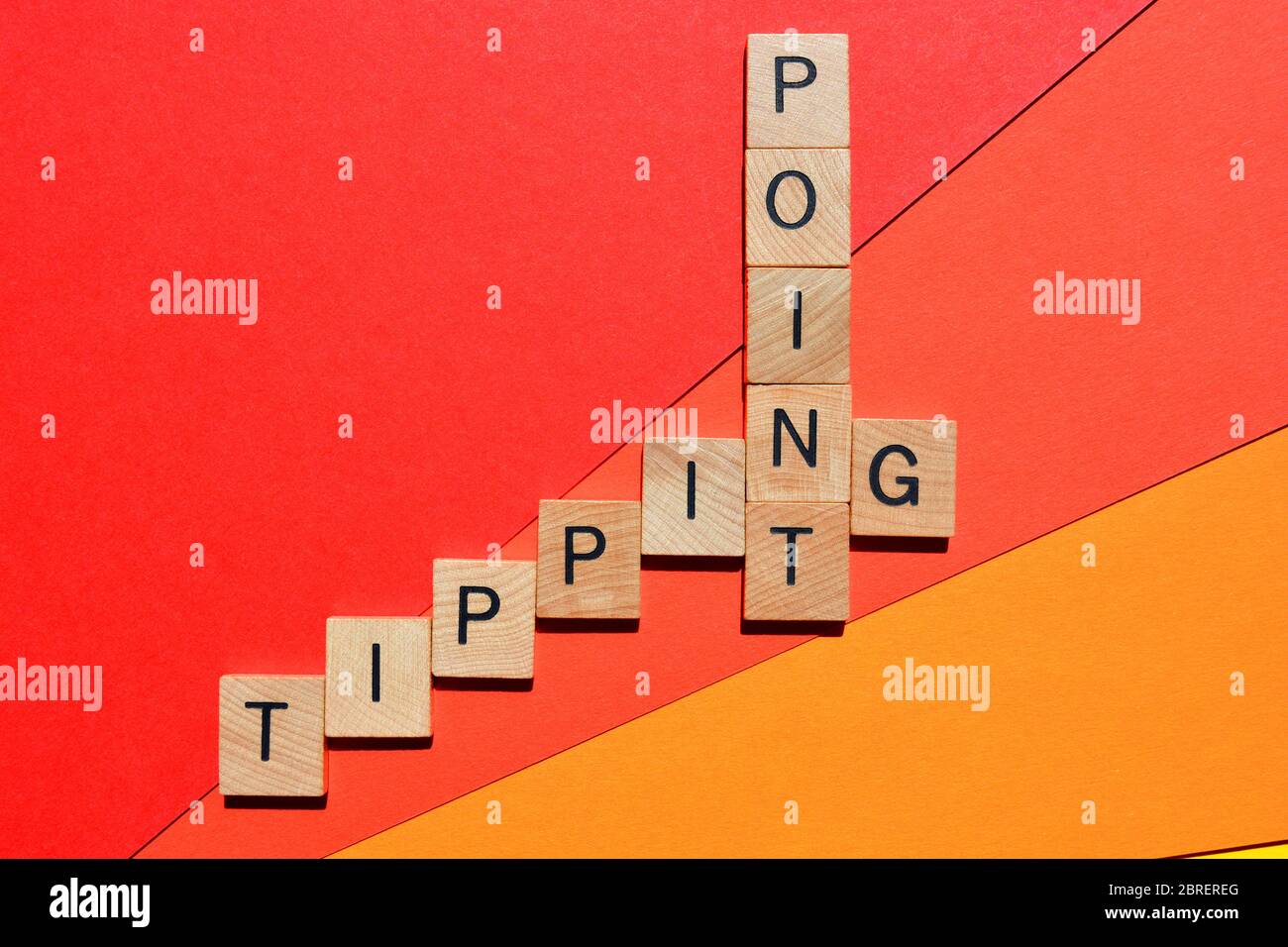 Kipppunkt, Kreuzworträtsel in Holzbuchstaben isoliert auf rotem Hintergrund Stockfoto