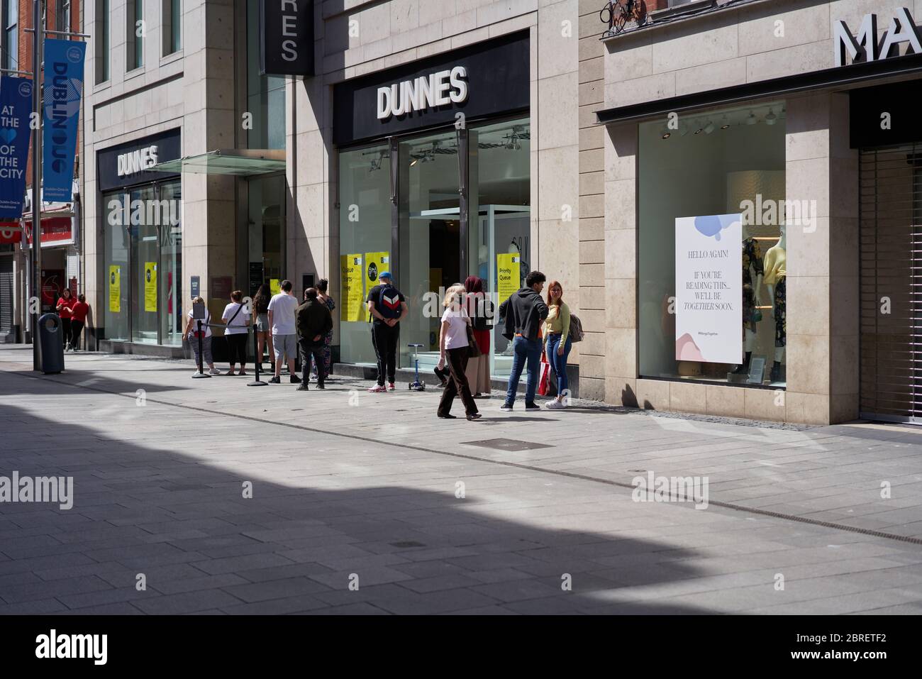 Während der weltweiten Coronavirus-Pandemie bilden die Menschen eine Schlange für Dunnes-Geschäfte in Dublin, Irland. Stockfoto