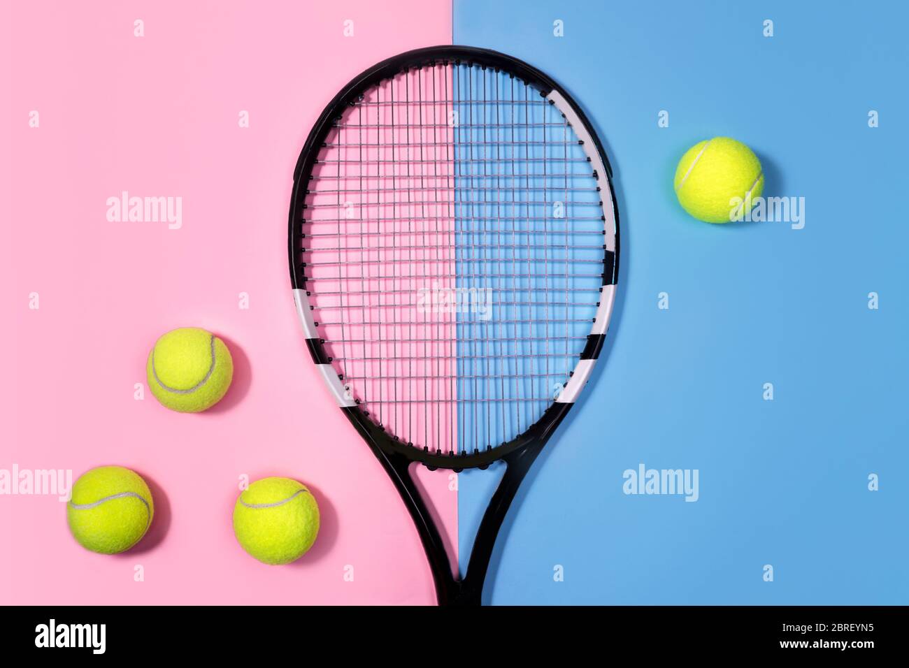 Tenniskonzept mit Bällen und Tennisschläger auf pastellrosa und blauem Hintergrund. Draufsicht, Kopierbereich. Stockfoto