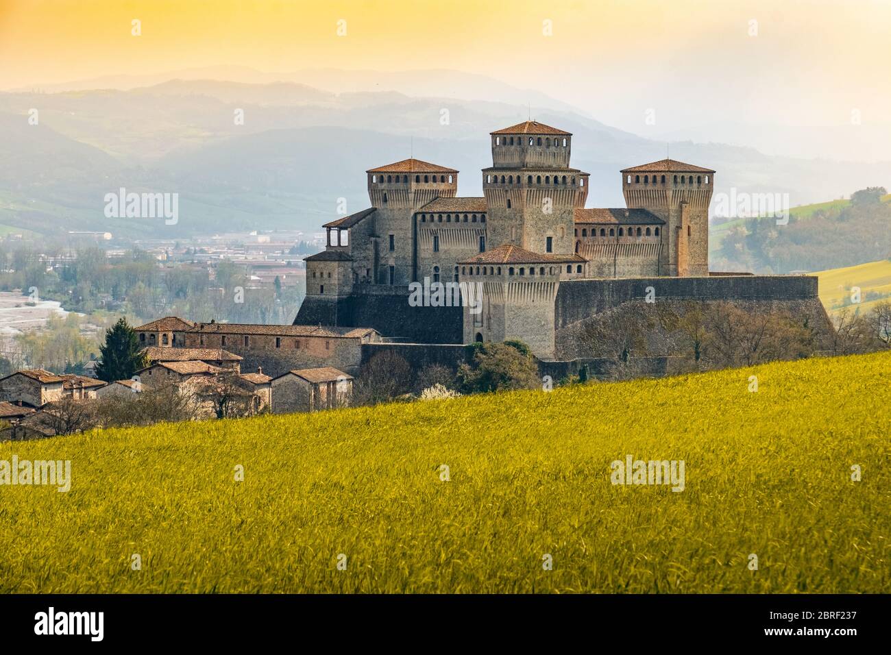 Wahrzeichen italiens, das Fantasy-Schloss Torrechiara bei Parma - Italien mit gelb-warmem Gras und Himmel Vintage-Look mit Kopierraum Stockfoto